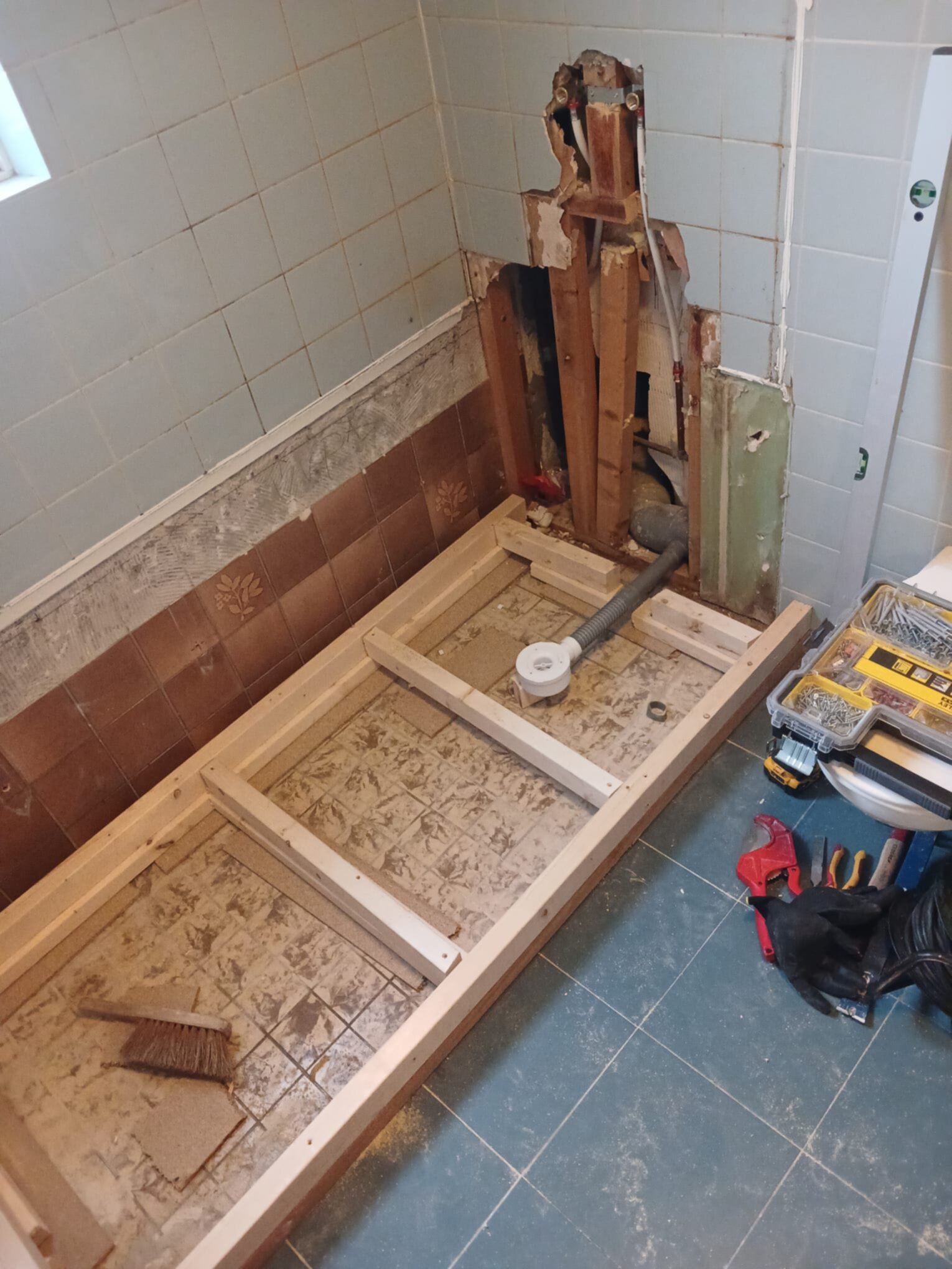 Sloop badkamer met gereedschap en houten frame voor nieuwe vloer