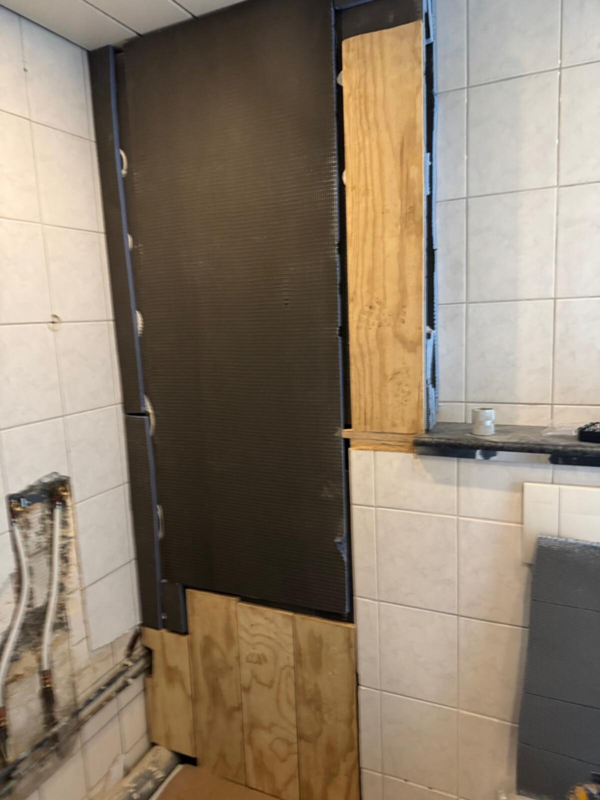 Tijdens badkamer renovatie, betegelde muren met bruine en houten panelen