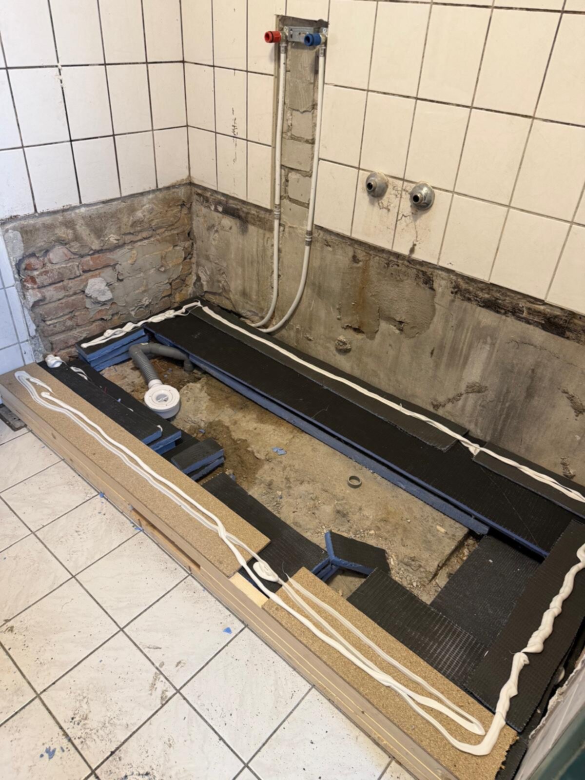 Badkamer renovatie tijdens werkzaamheden, open badkuip en betegelde muren