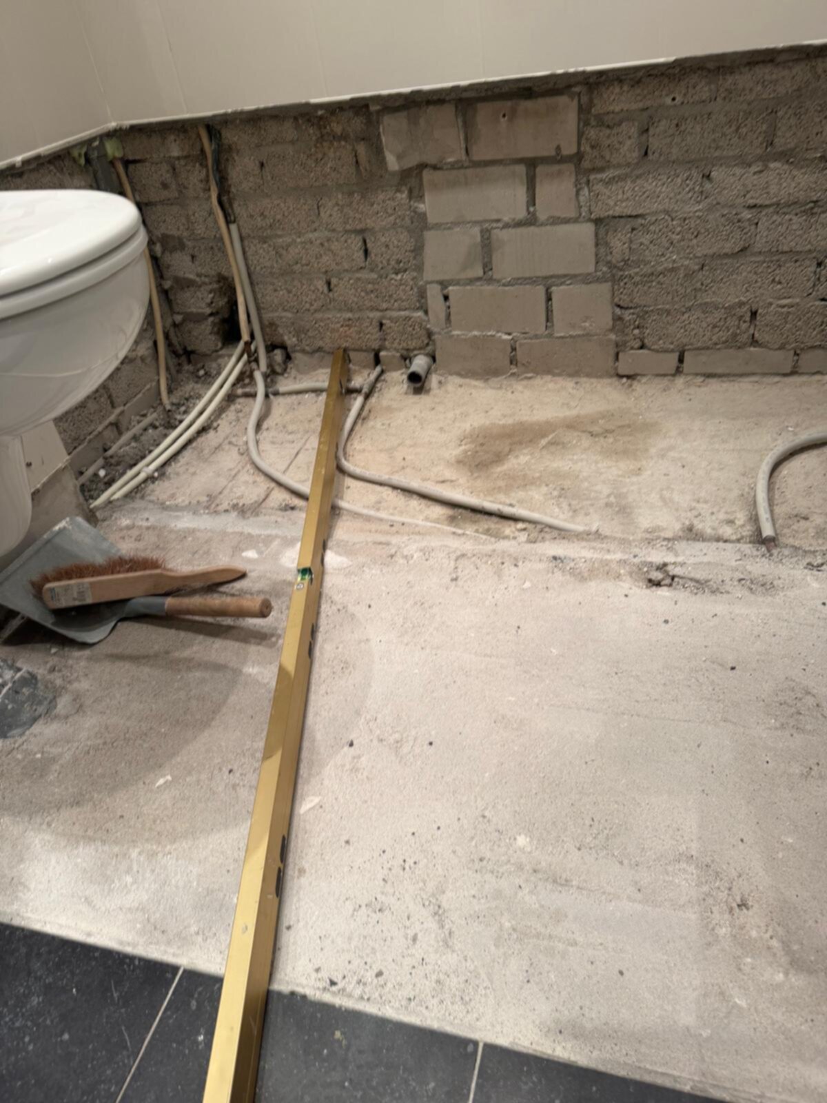 Badkamer in renovatie, toilet en kale materialen zichtbaar