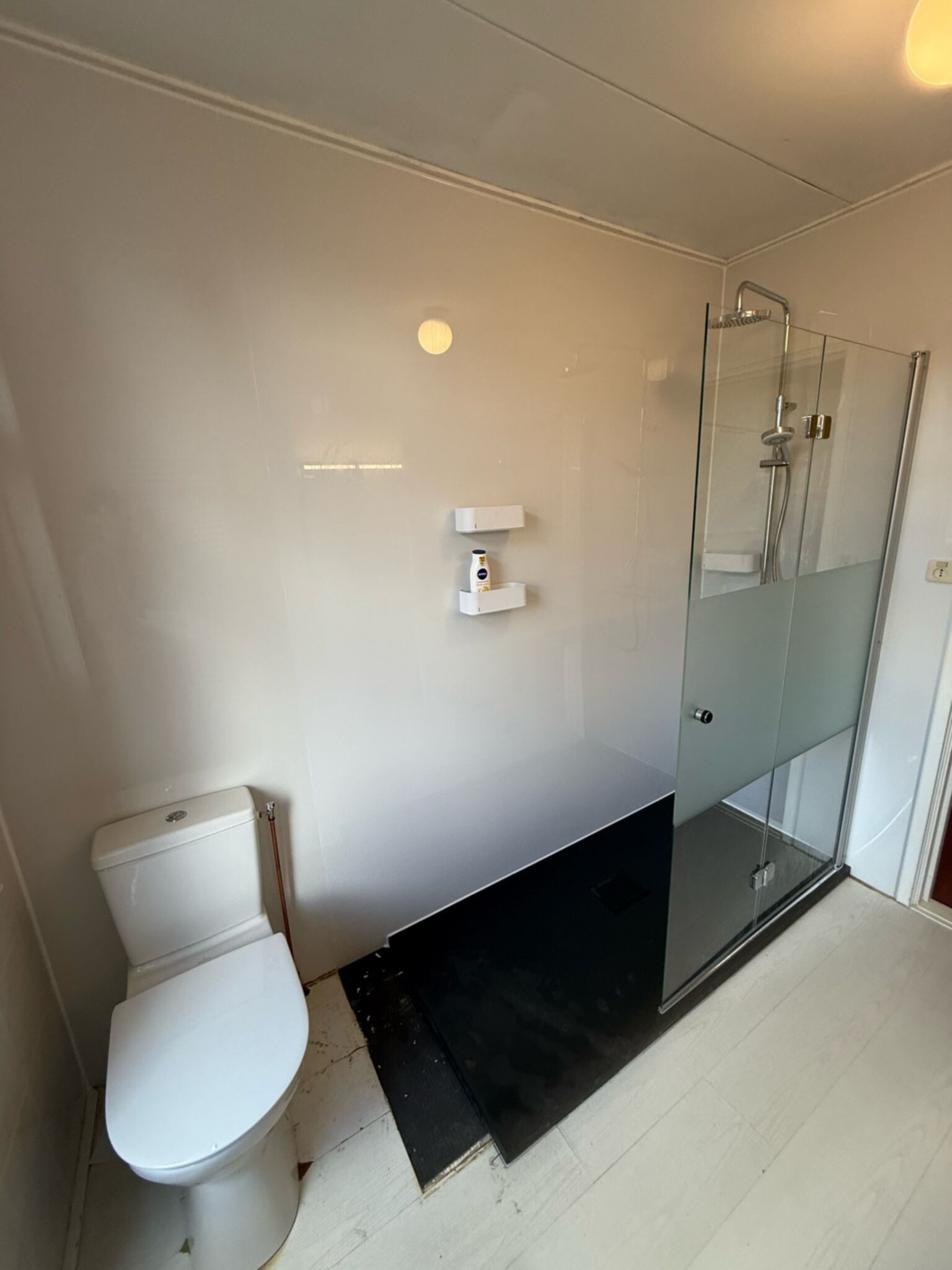 Schoon wit toilet en douche in moderne badkamer