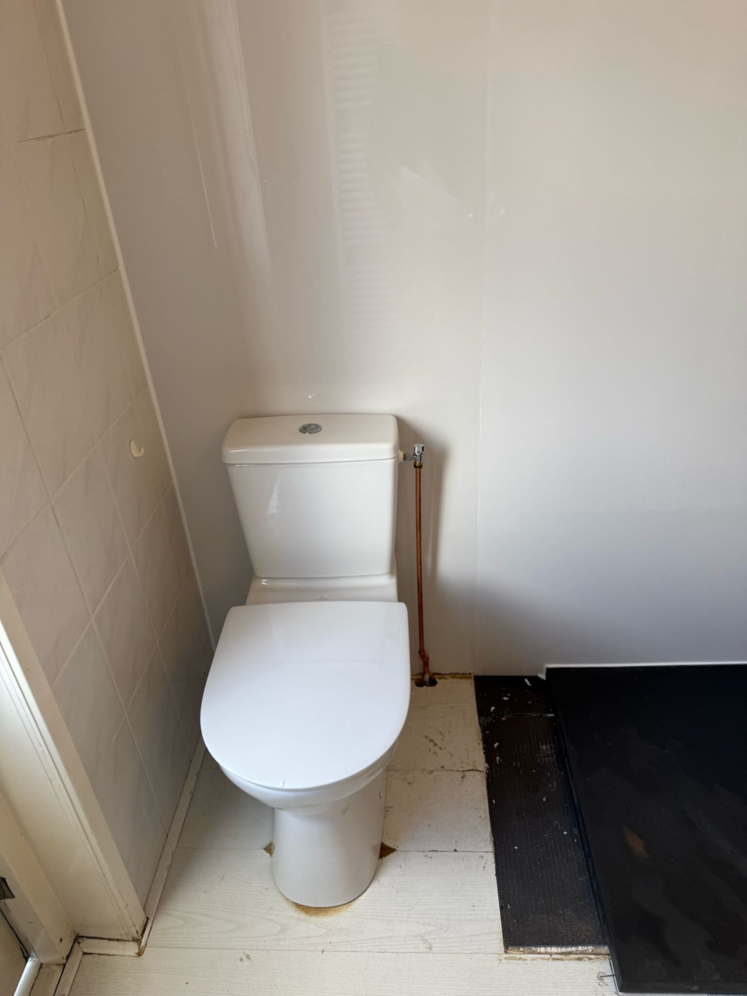Wit toilet in badkamer met witte muren en betegelde wand