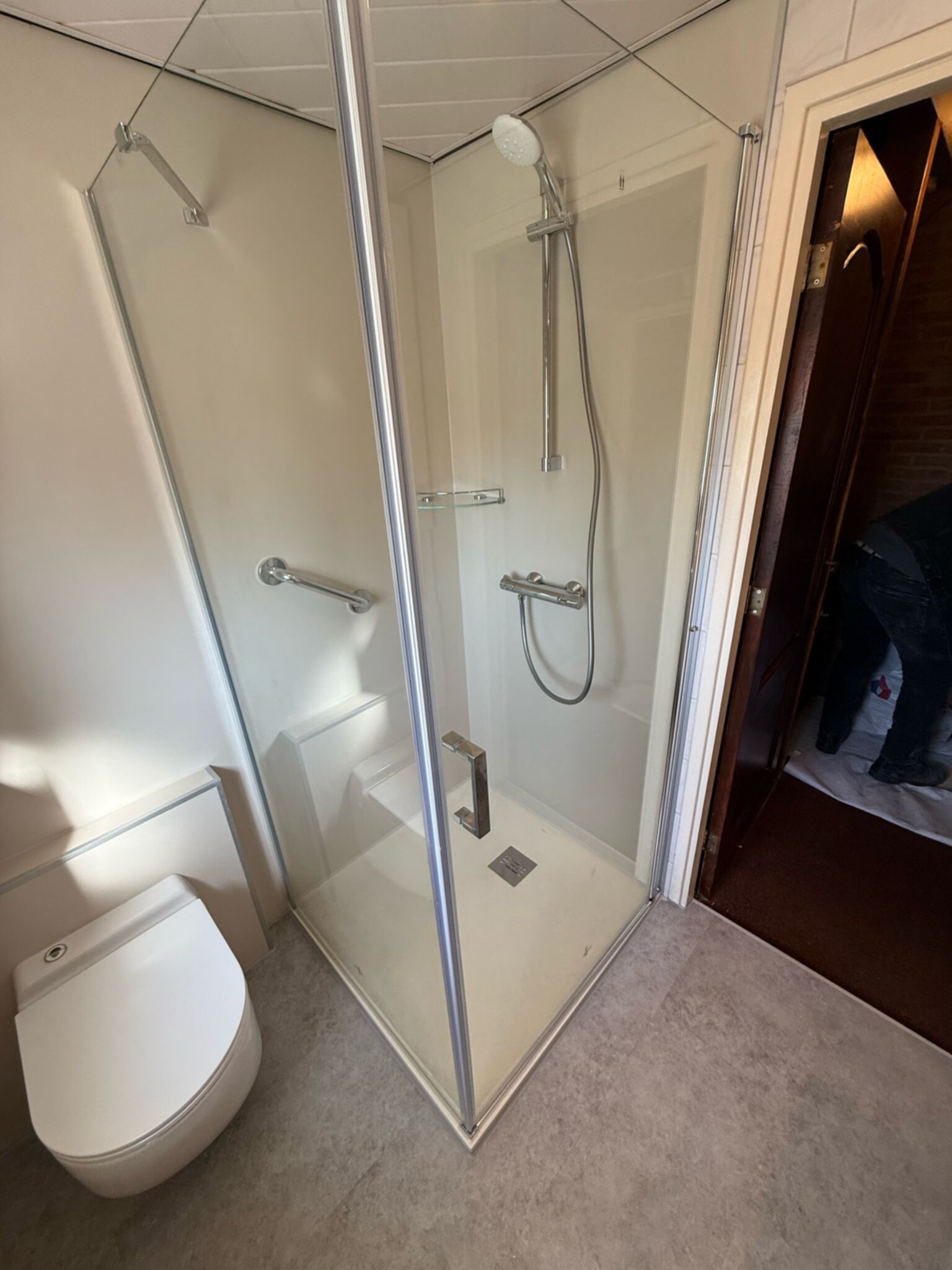 Moderne badkamer met glazen douchecabine en witte toilet