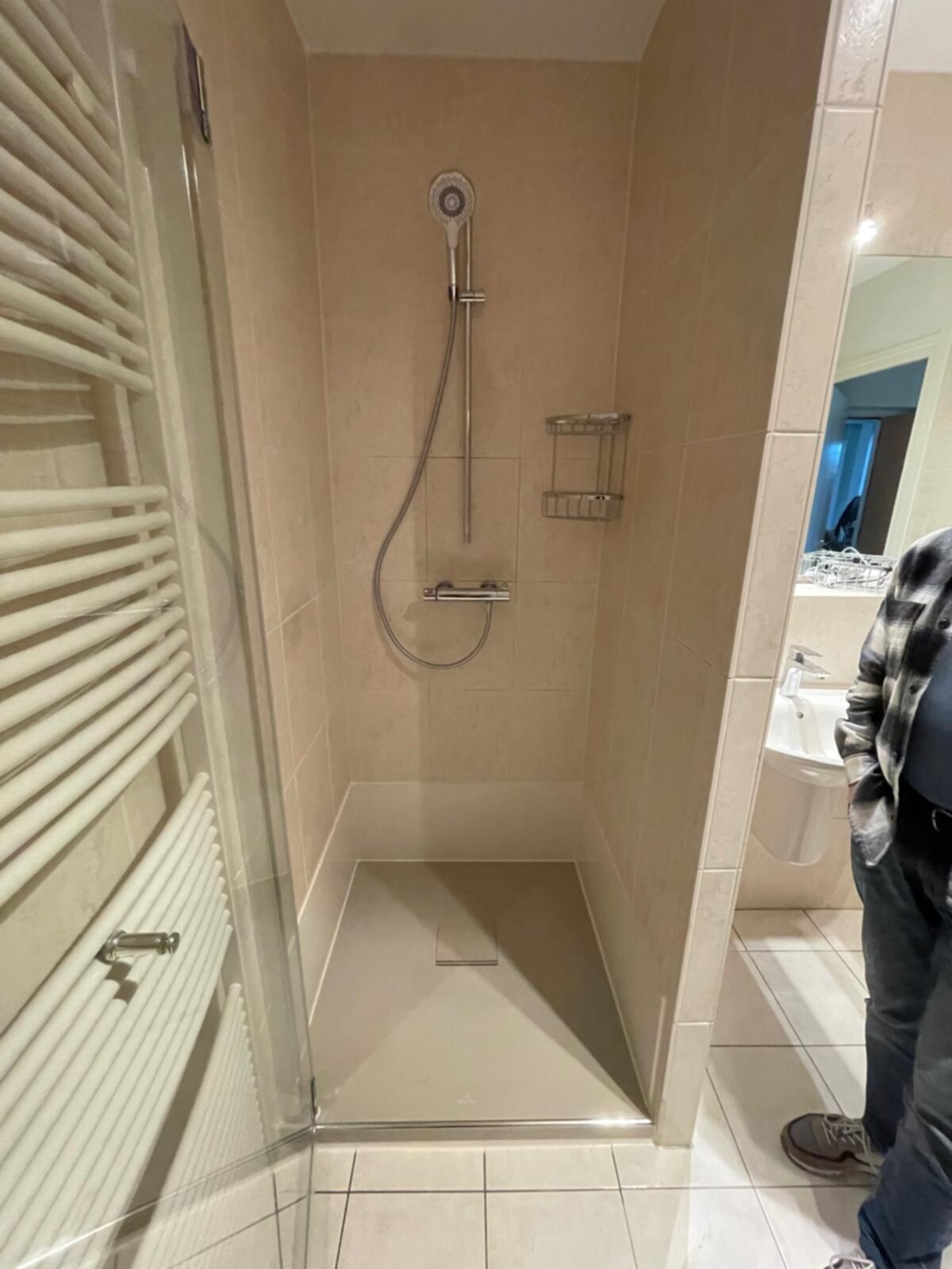 Douchecabine met beige tegels en glazen deur