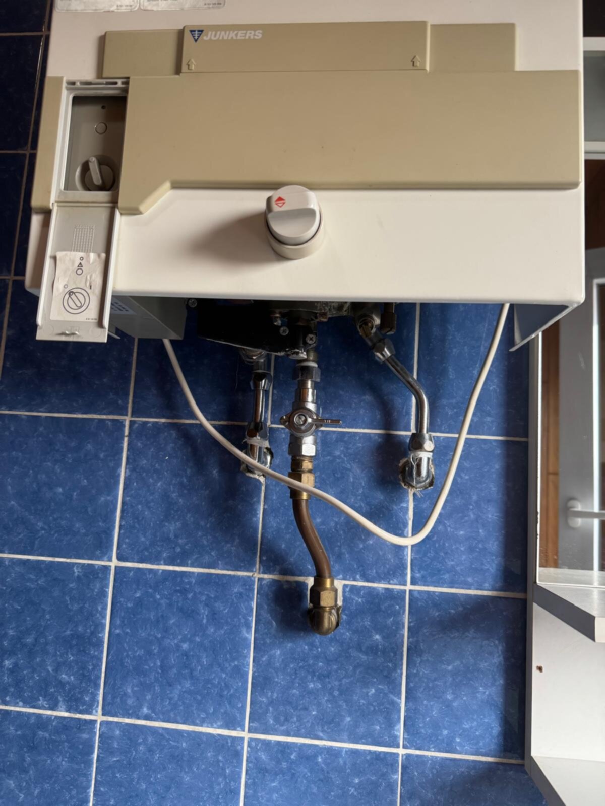 bestaande badkamer tegelvloer met blauwe tegels en witte kit, Junkers verwarmingselement