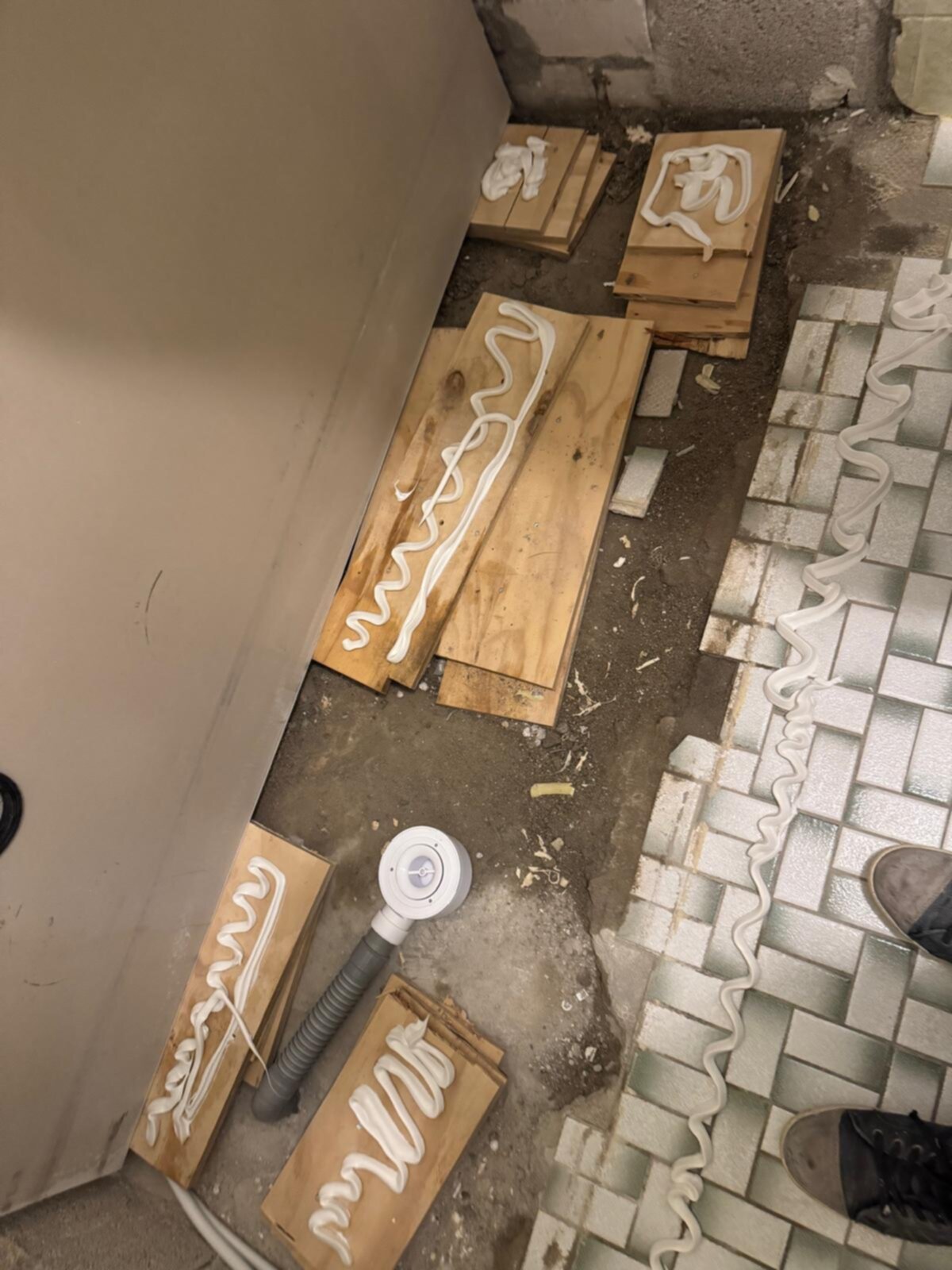 Badkamer renovatie, houten planken en siliconen op de grond