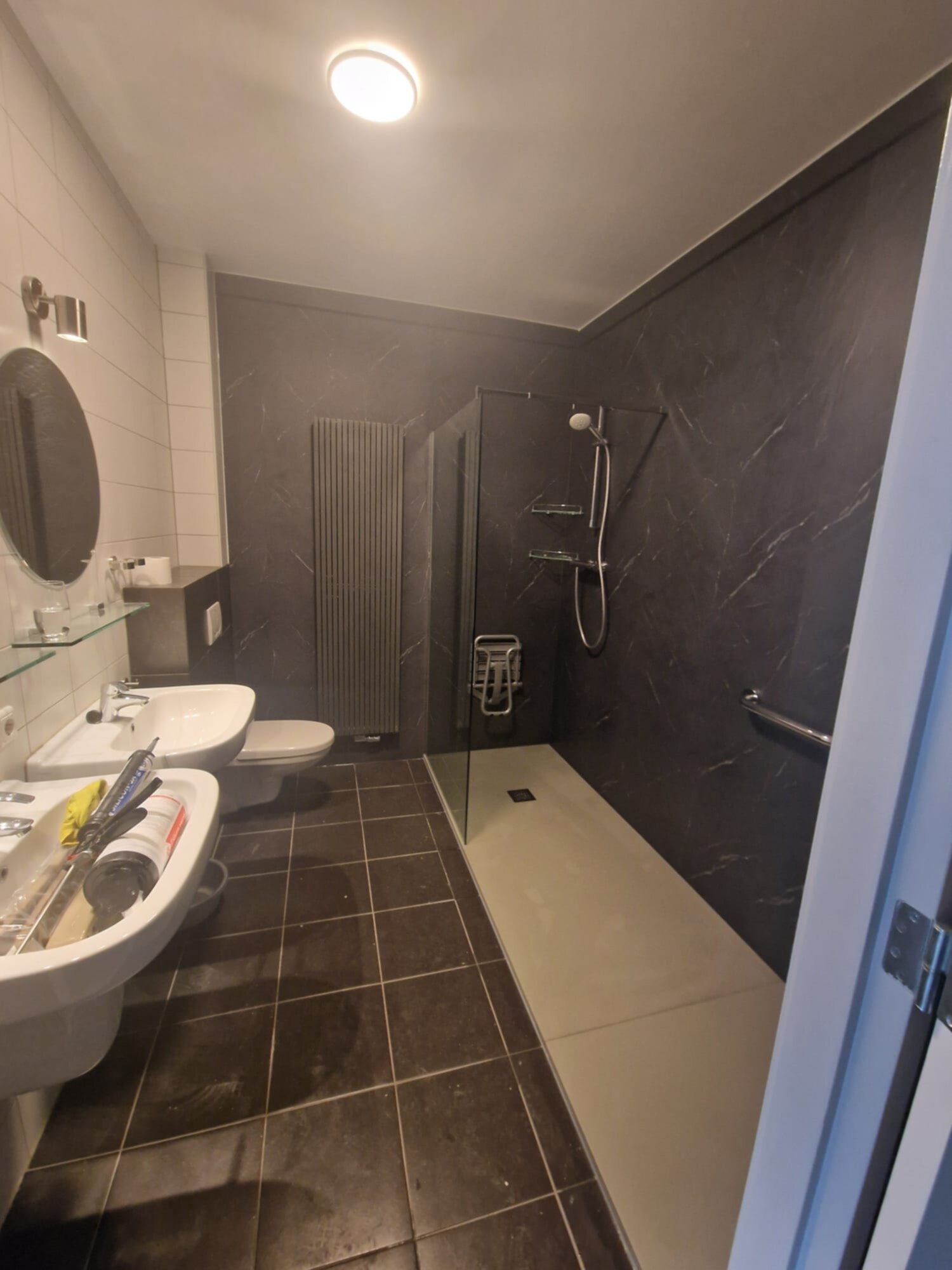 Moderne badkamer met donkere marmeren muren en witte sanitair