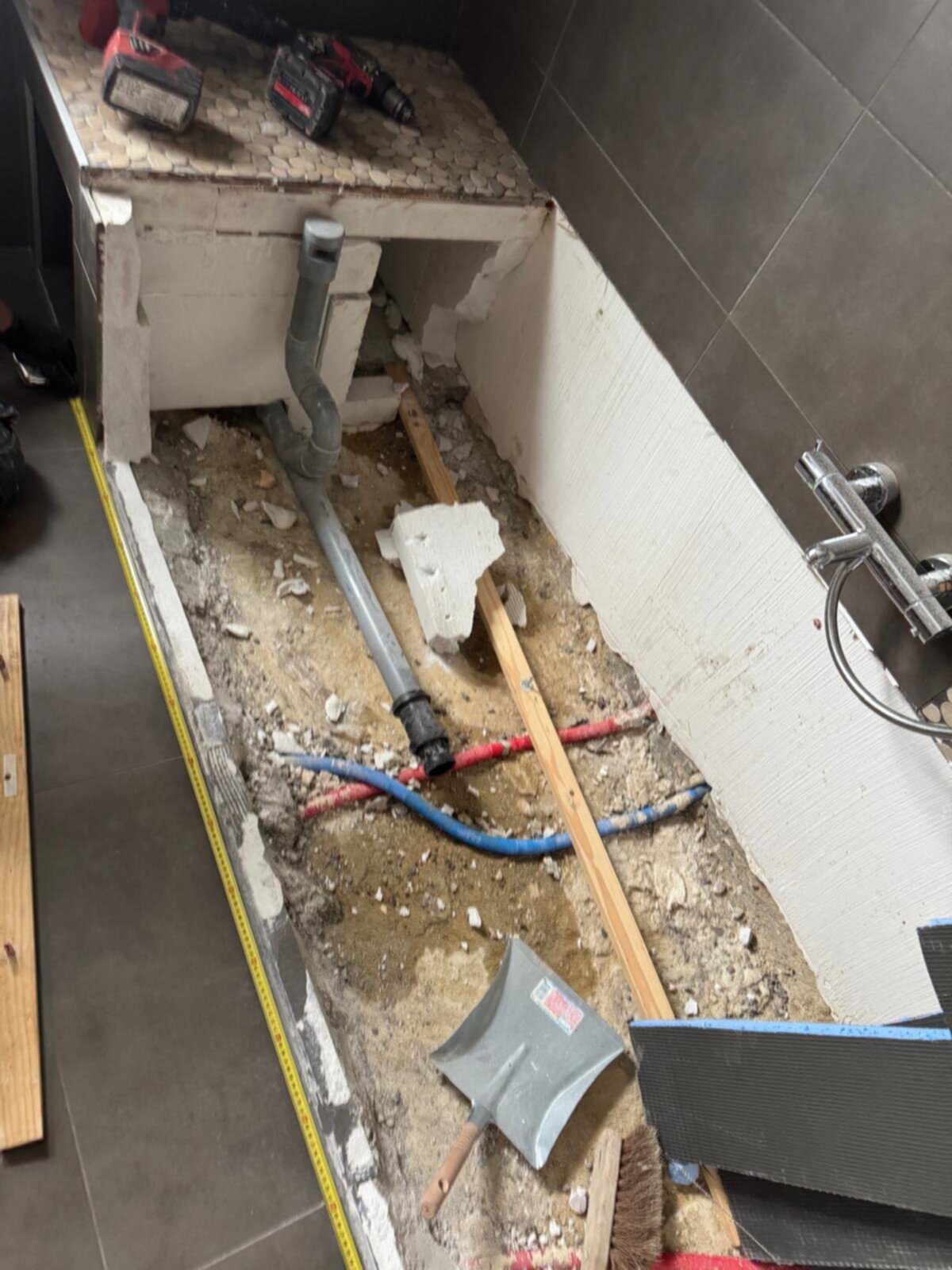 Sloopwerkzaamheden in badkamer met opengelekte vloer en blootgelegde leidingen
