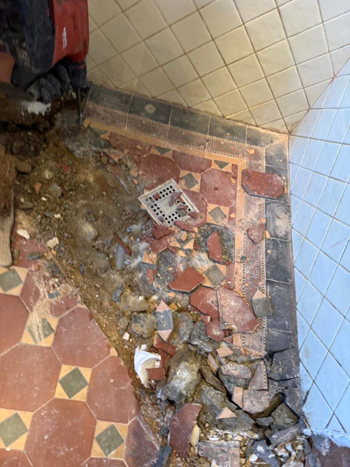 Sloop badkamer vloer met kapotte tegels en gereedschap