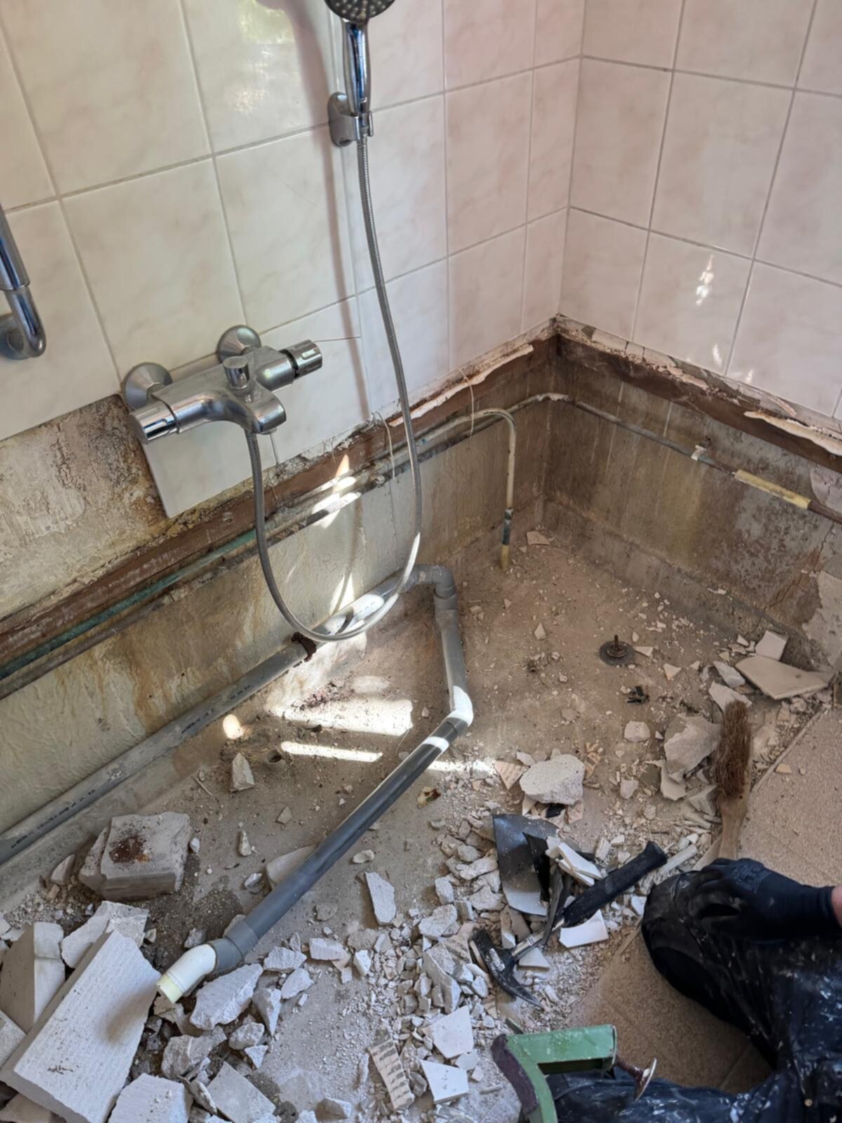 Slechte staat badkamer met kapotte tegels en oude sanitaire voorzieningen