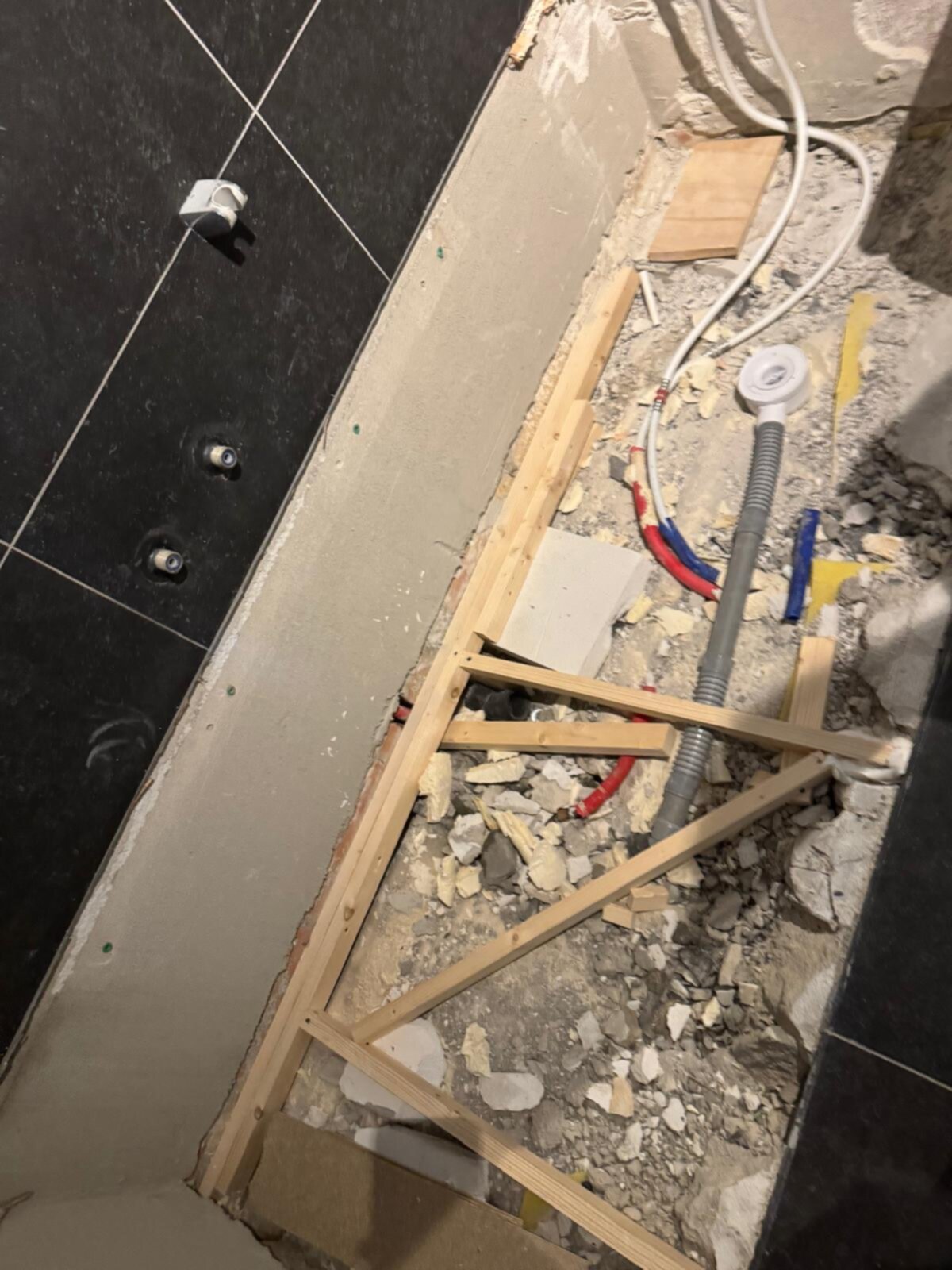 Sloopwerk badkamer met houten constructie en blootgelegde leidingen