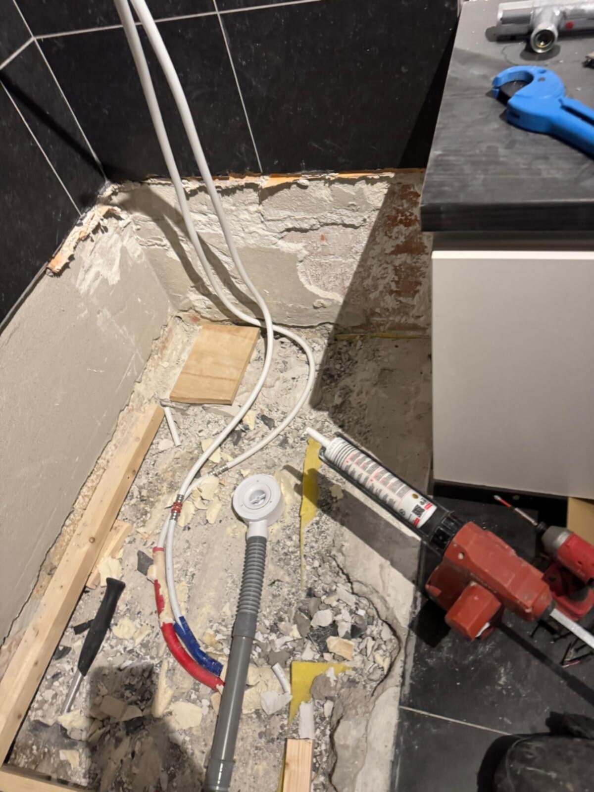 Sloopwerk badkamer renovatie met kabels, leidingen en gereedschap