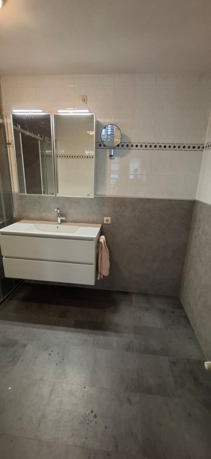Moderne badkamer met witte wastafel en grote spiegel