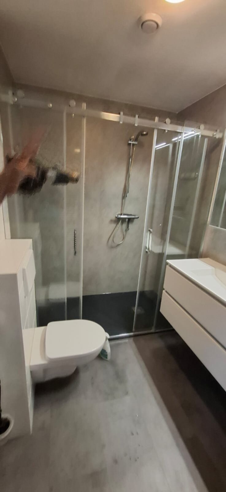 Moderne badkamer met glazen douchecabine, witte toilet en wasbak