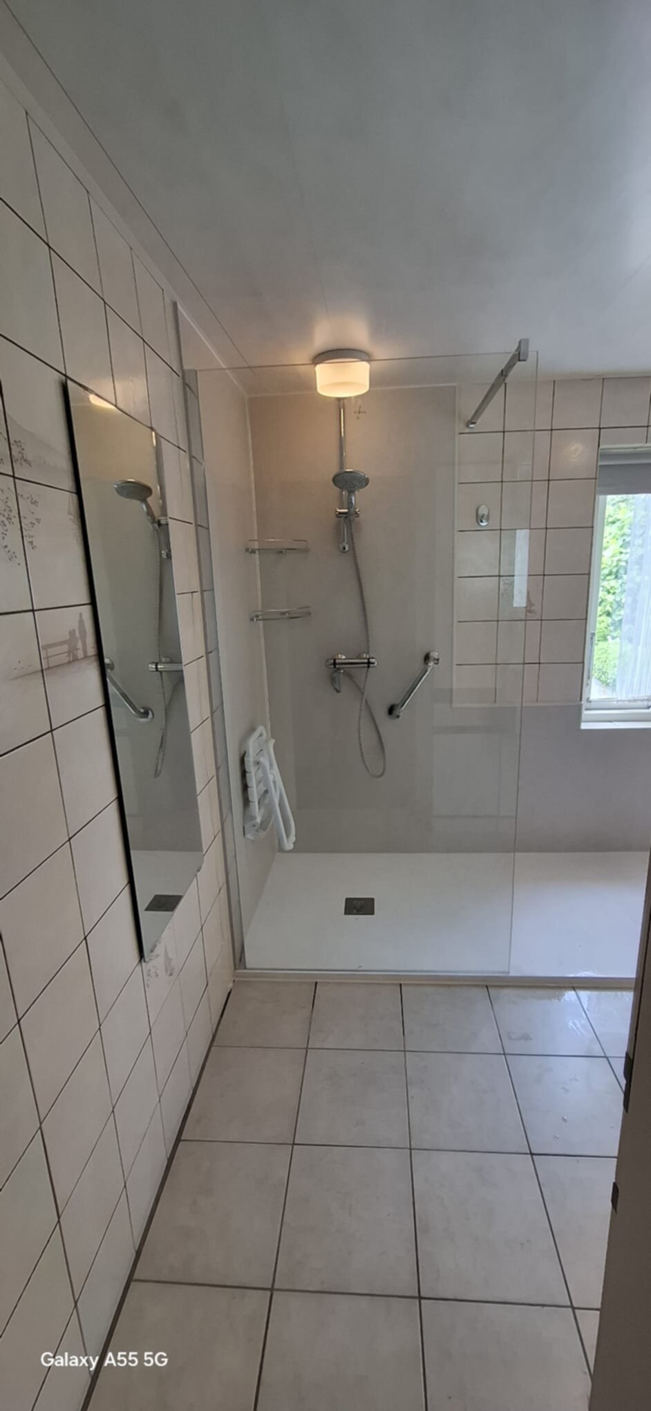 Douchecellen met betegelde wanden en vloer in beige en witte tonen