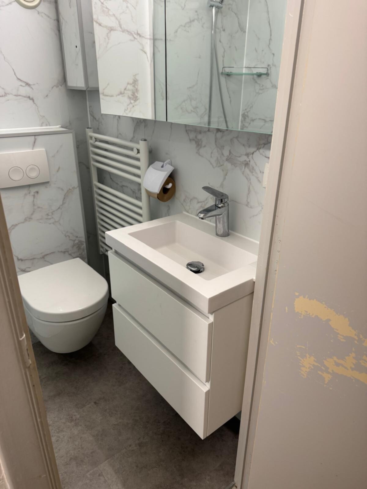 Moderne witte badkamer met marmerlook tegels en grijze vloer