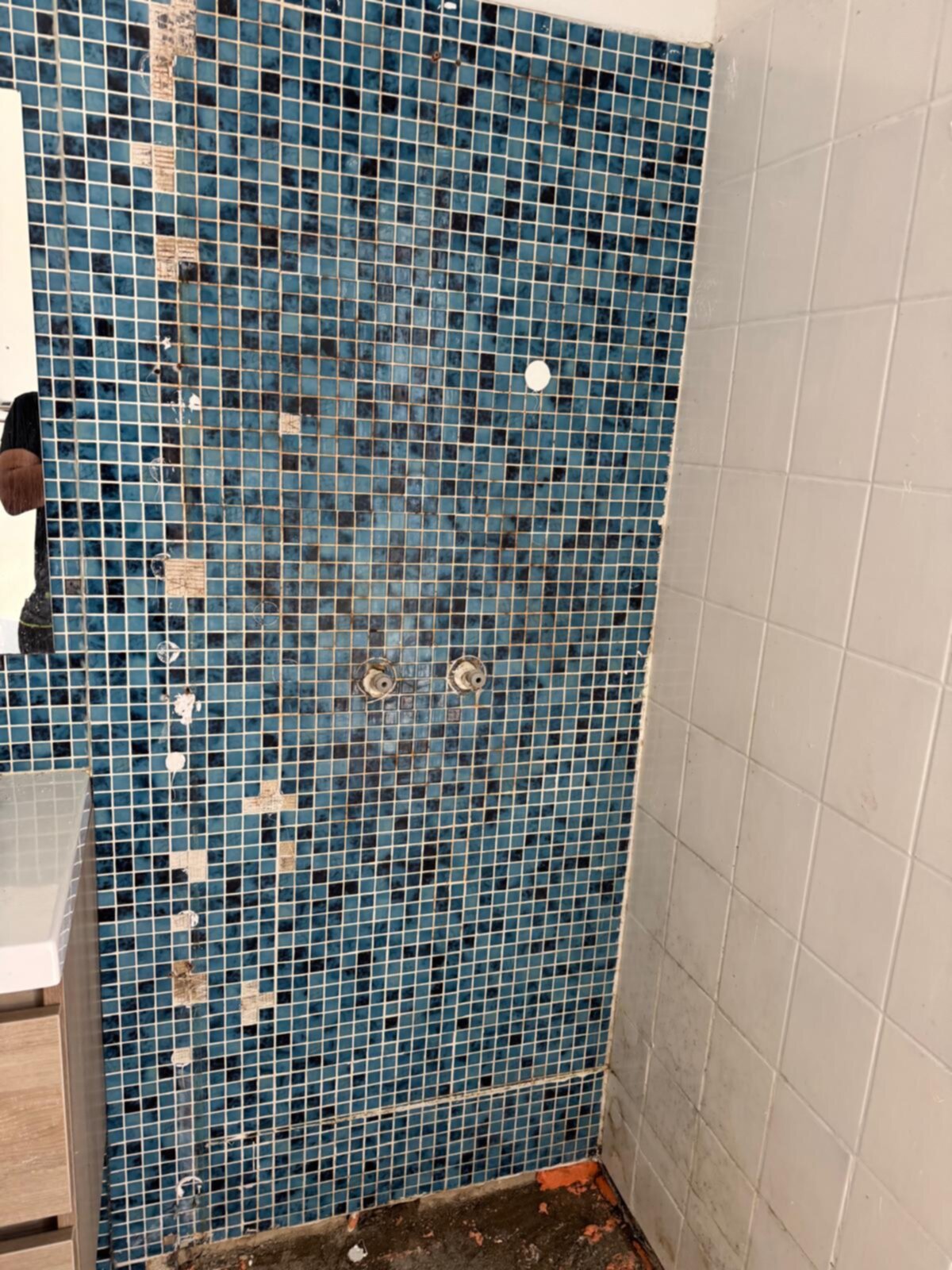 Blauwe mozaïek tegels op badkamer wand voor renovatie