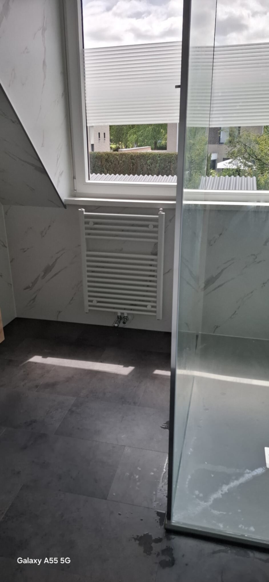 Grote badkamer met grijze tegelvloer en marmeren wandpanelen