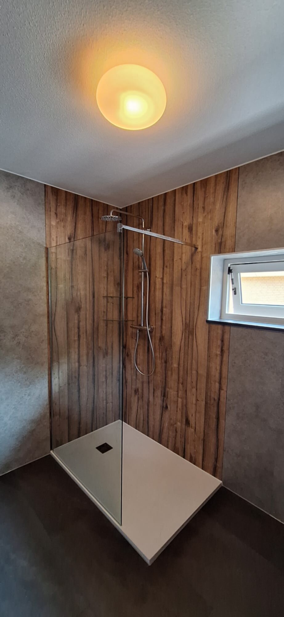 Douchecabine met houten panelen en witte douchebak