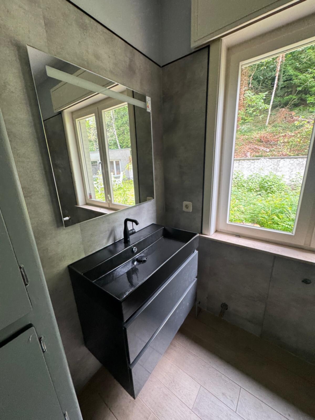 Moderne badkamer met zwarte wastafel en grijze wanden