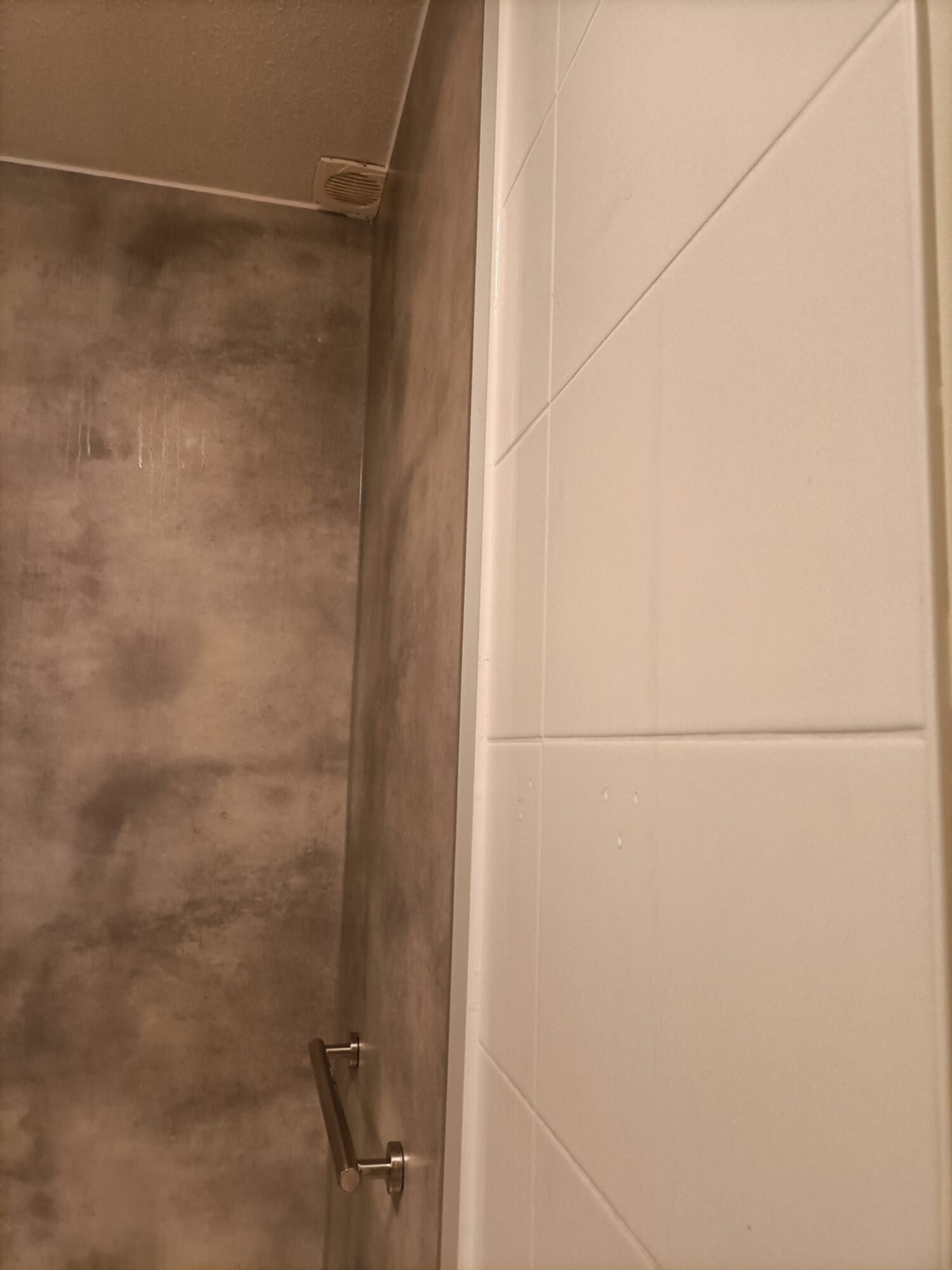 Douche met grijze wand en witte betegeling