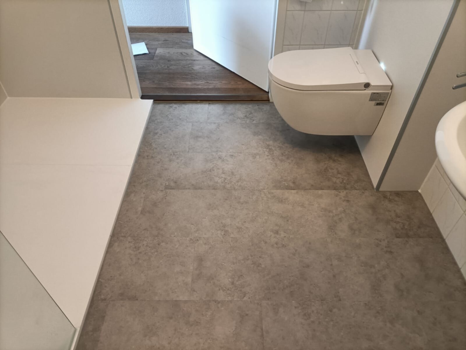 Badkamer vloer en toilet in moderne stijl met grijze tegels en witte accenten
