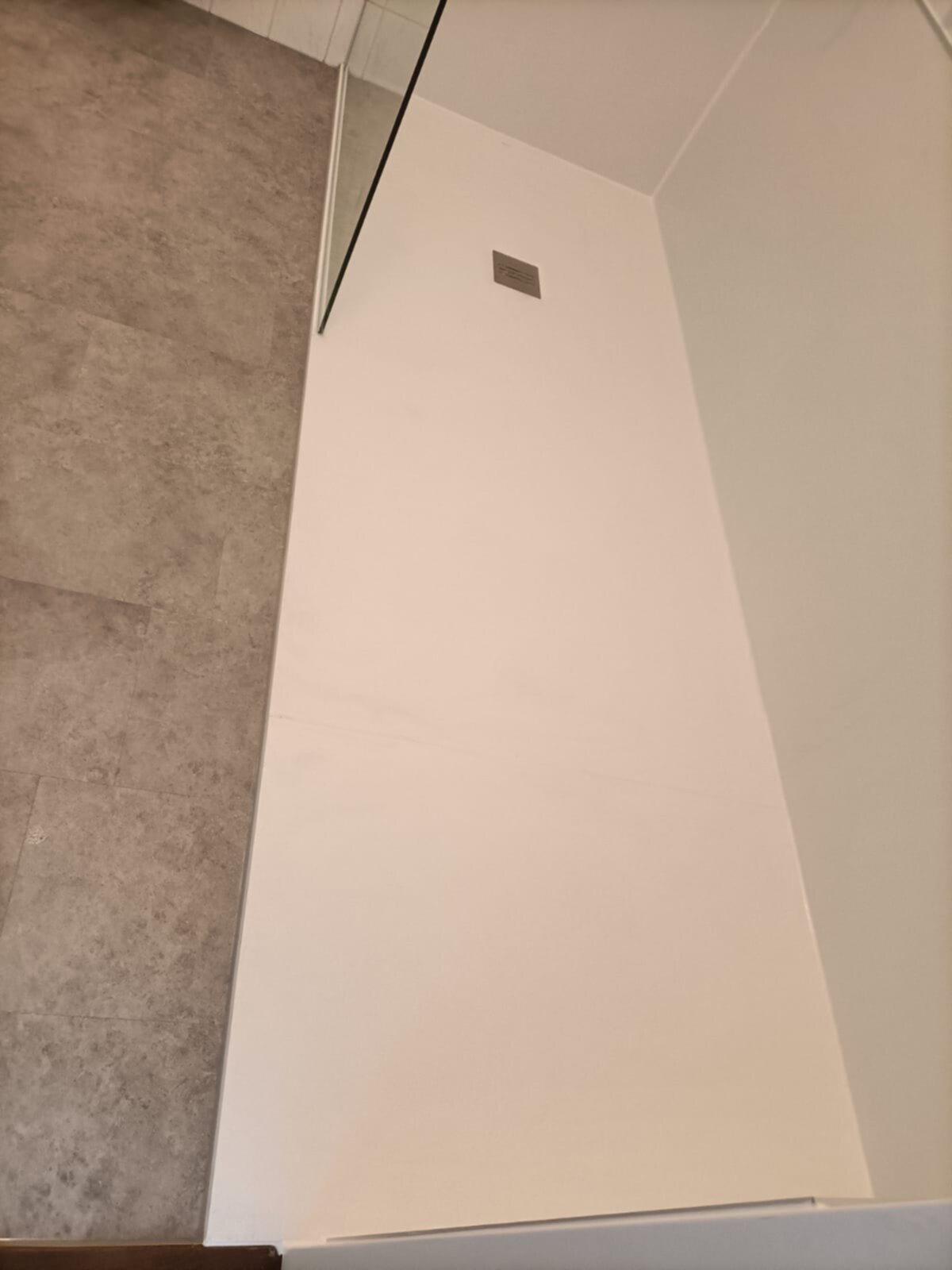 Witte wand en bruine vloer in badkamer