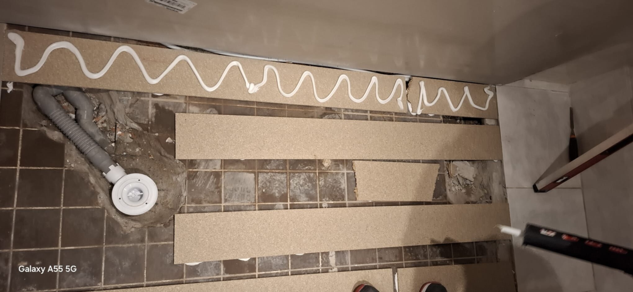 Renovatie badkamer vloer met nieuwe tegels en siliconen afdichting