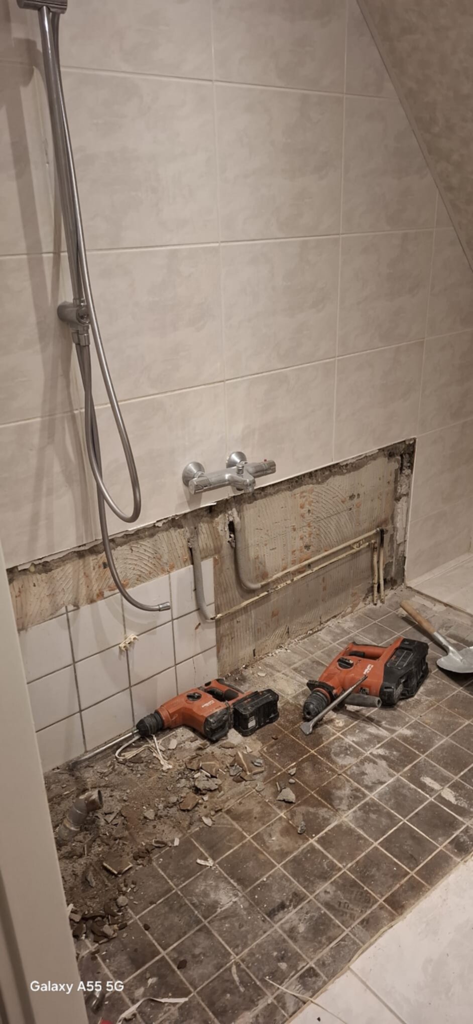 Sloopwerk badkamer met gereedschap en opengelegd leidingwerk