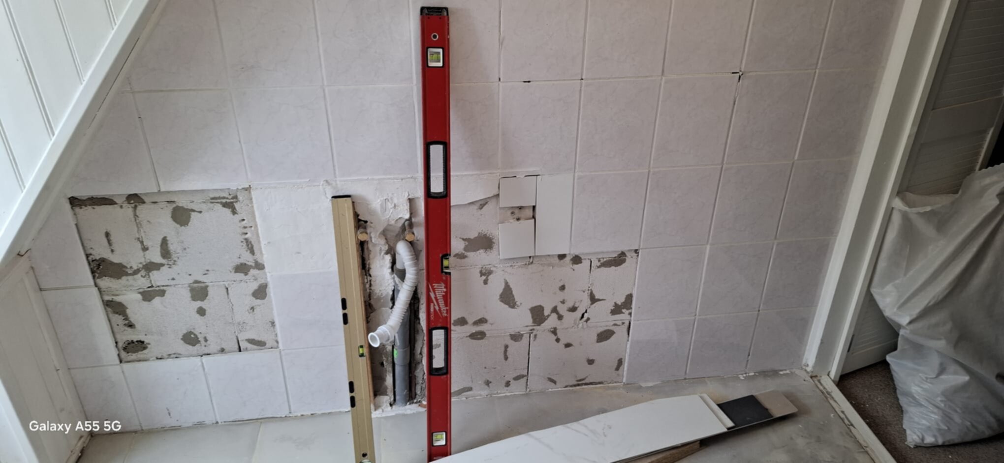 Badkamer renovatie in uitvoering, oude tegels verwijderen en nieuwe voorbereiden