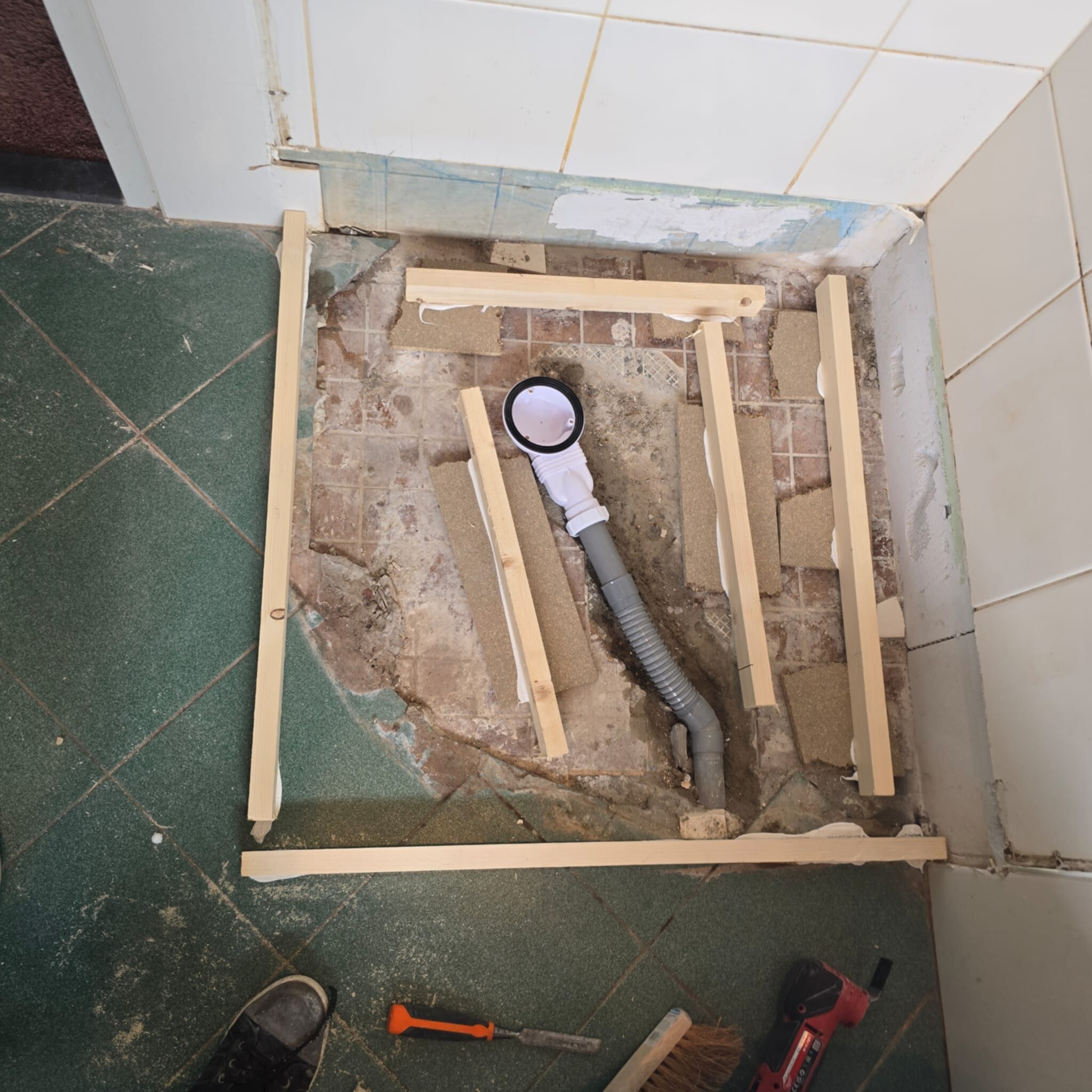 Douchevloer renovatie met houten frame en afvoerbuis