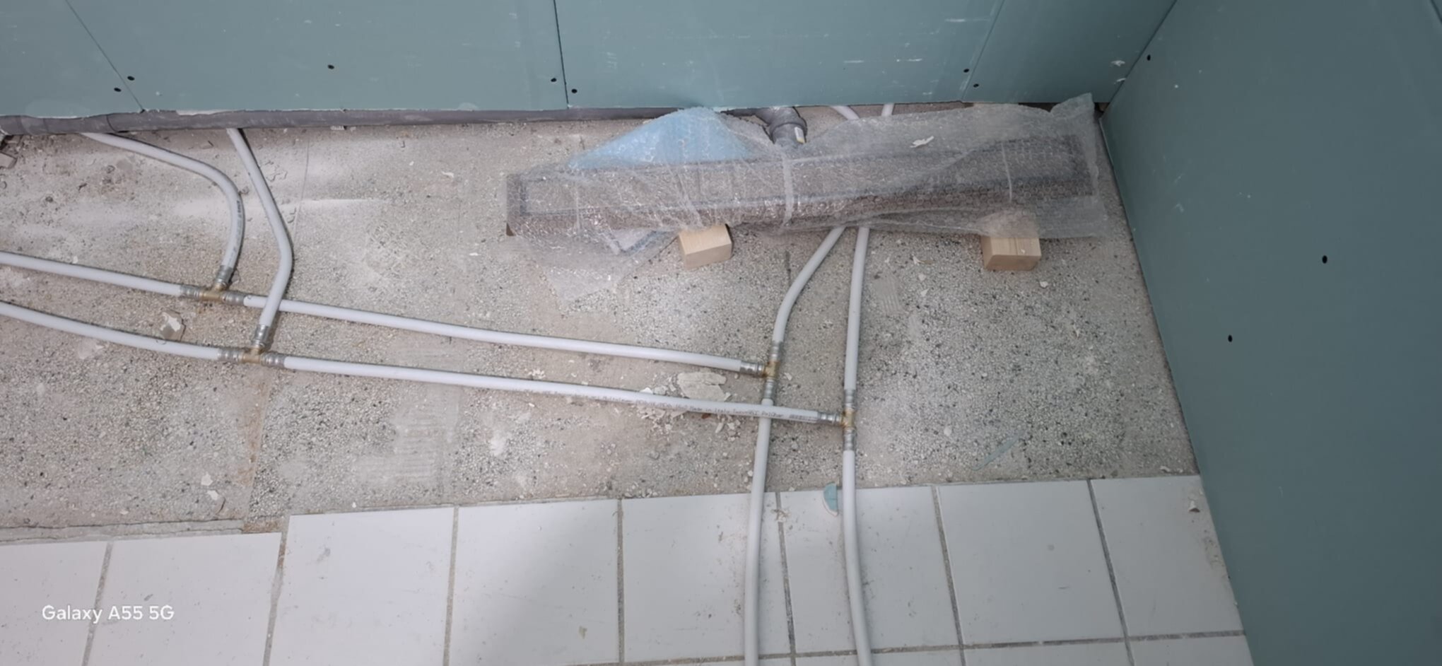 Badkamer renovatie, vloer met buizen en betegeling