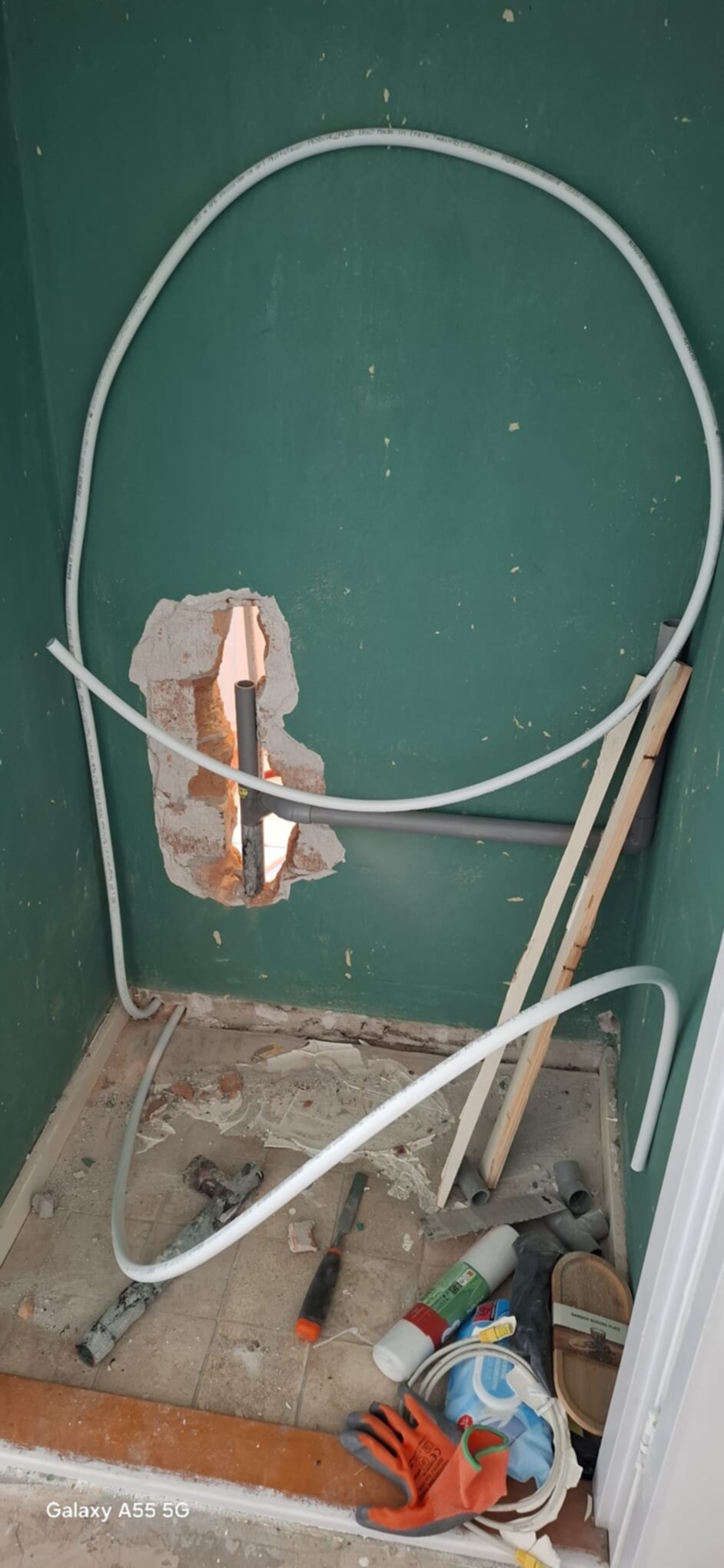 Spuitgemaakte badkamer met opengewerkte muur en vloer voor nieuwe installatie