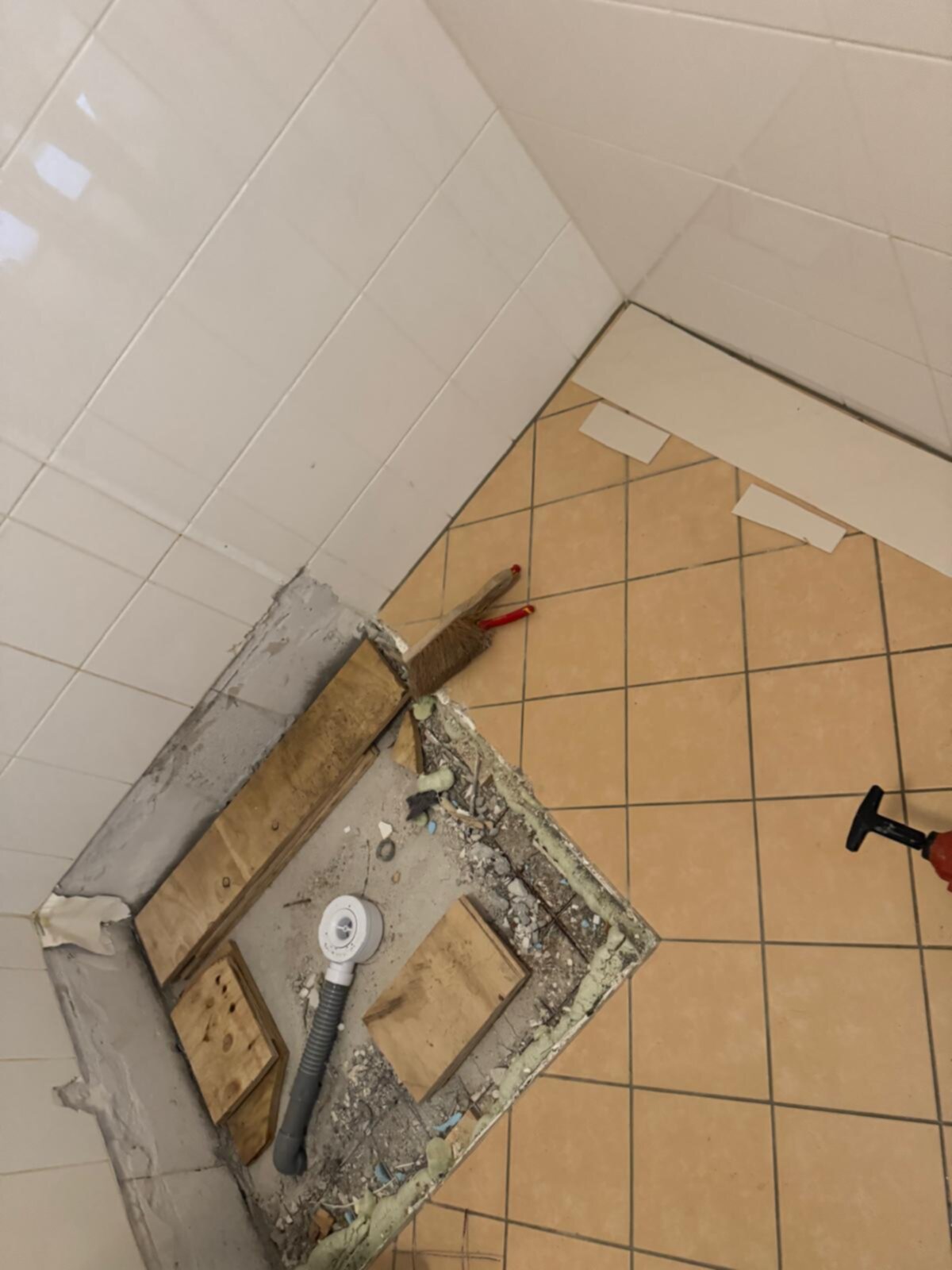Sloop badkamer met gereedschap en opengelegd leidingwerk