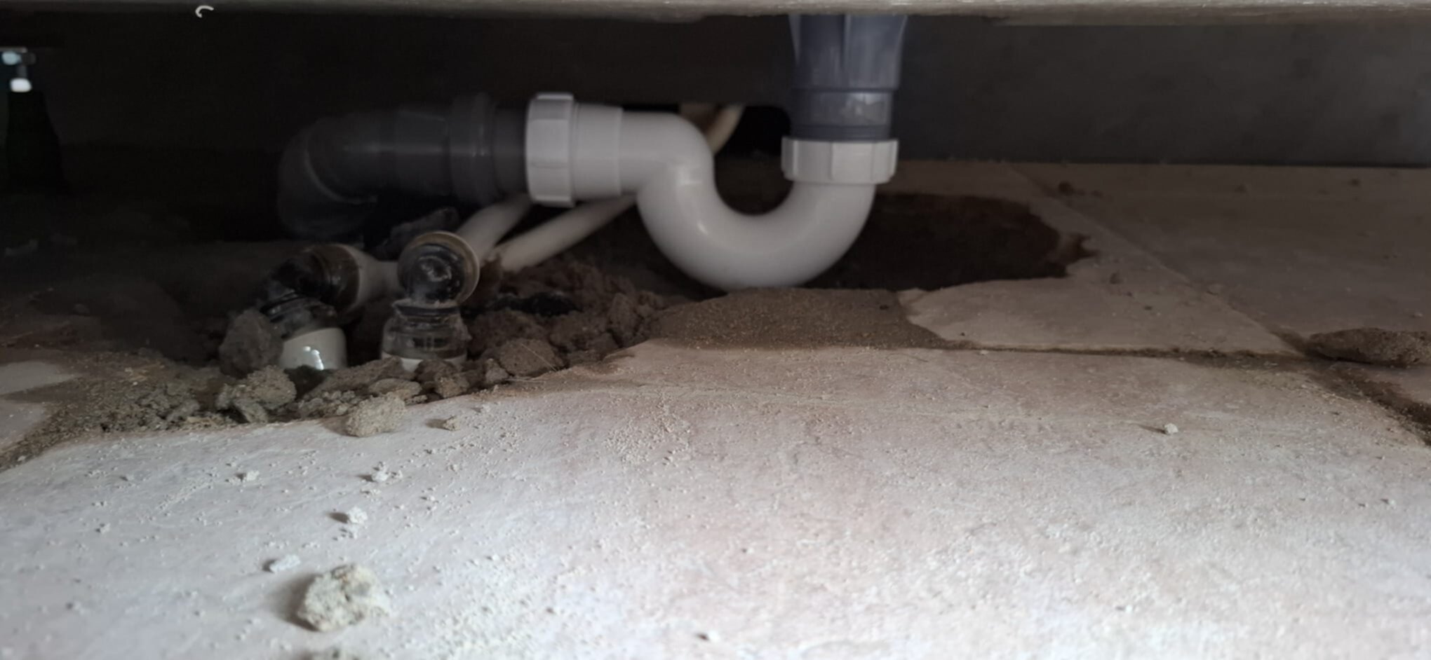 Sifon en rioleringsbuizen onder de vloer