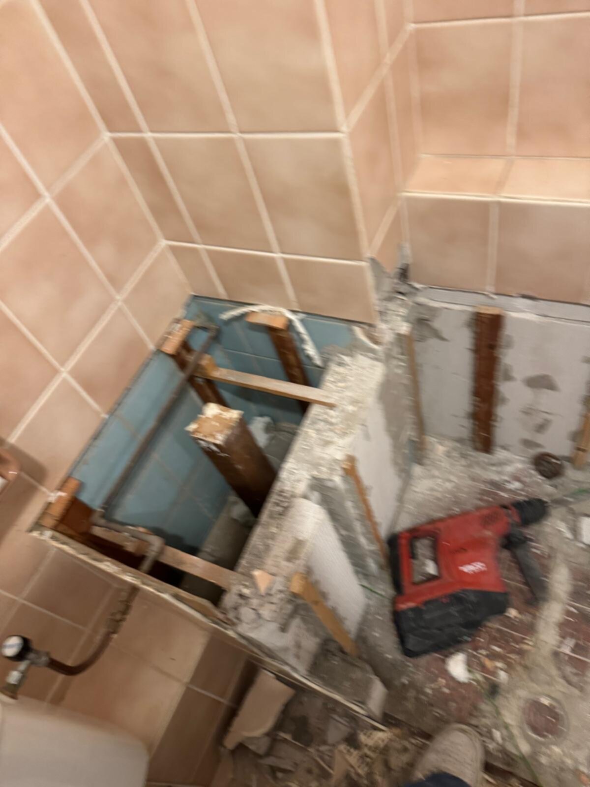 Sloopwerk badkamer met tegelwand en houten constructie