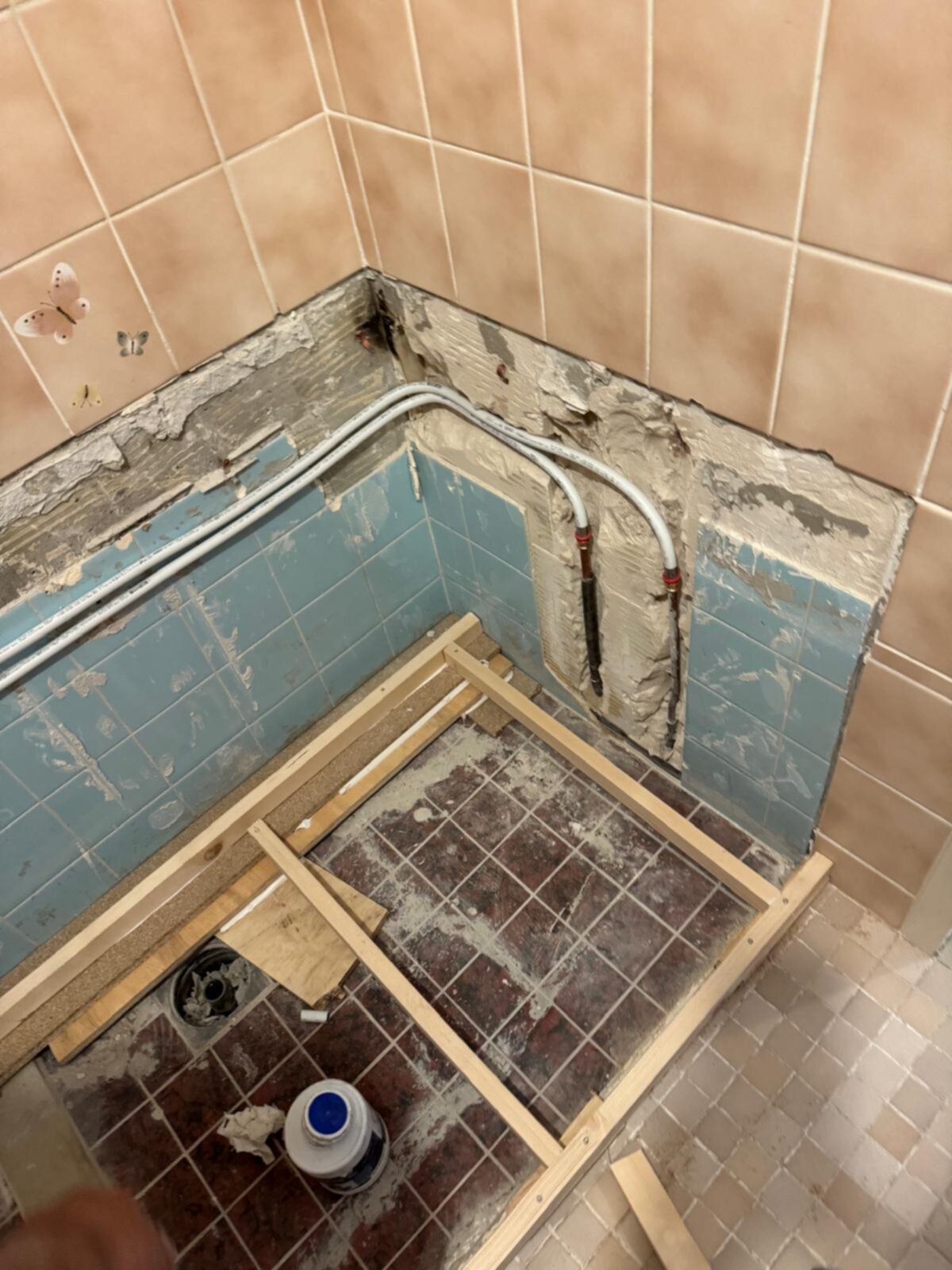 Sloop badkamer met zicht op betegelde muren en vloer met houten frame