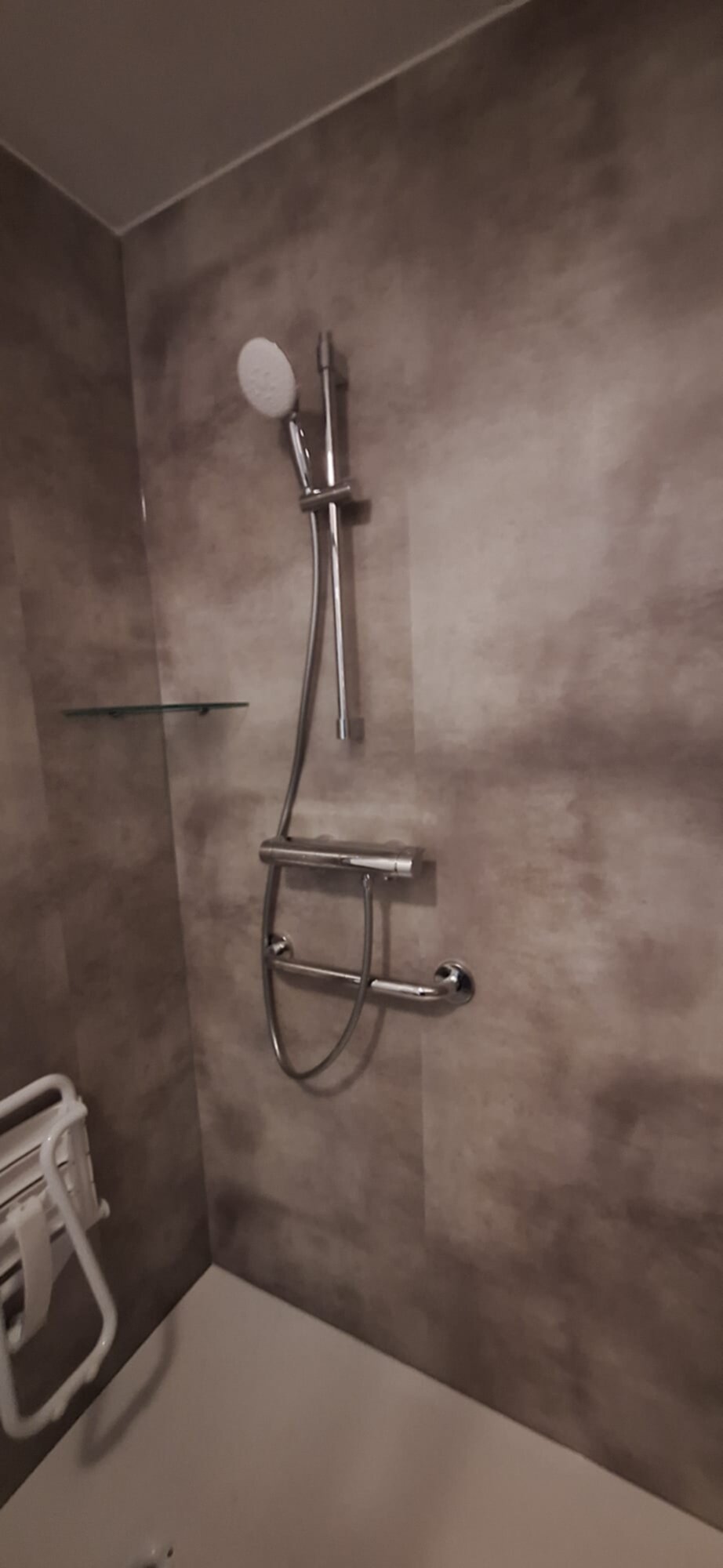 Douche met betegelde wand en moderne chromen douchekop en -kraan
