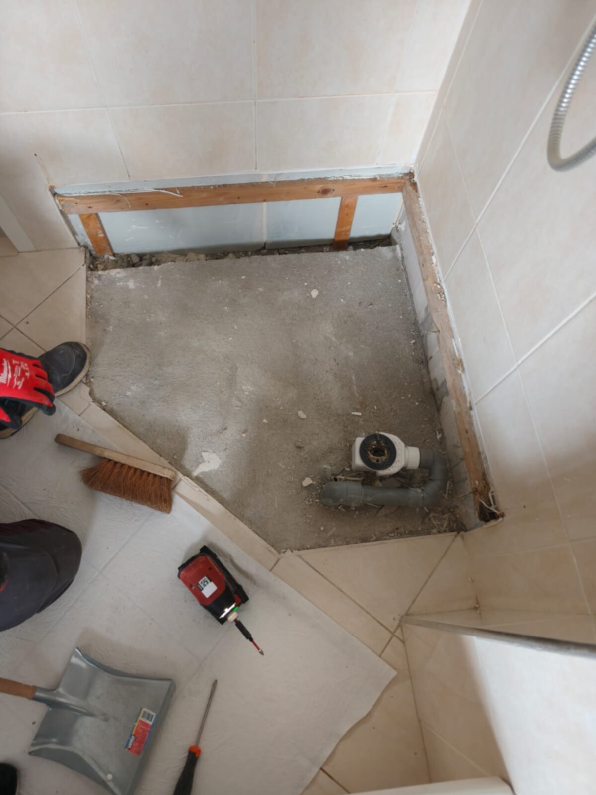 Badkamer renovatie, betegelde muren en vloer, gereedschap en materialen voor nieuwe douche