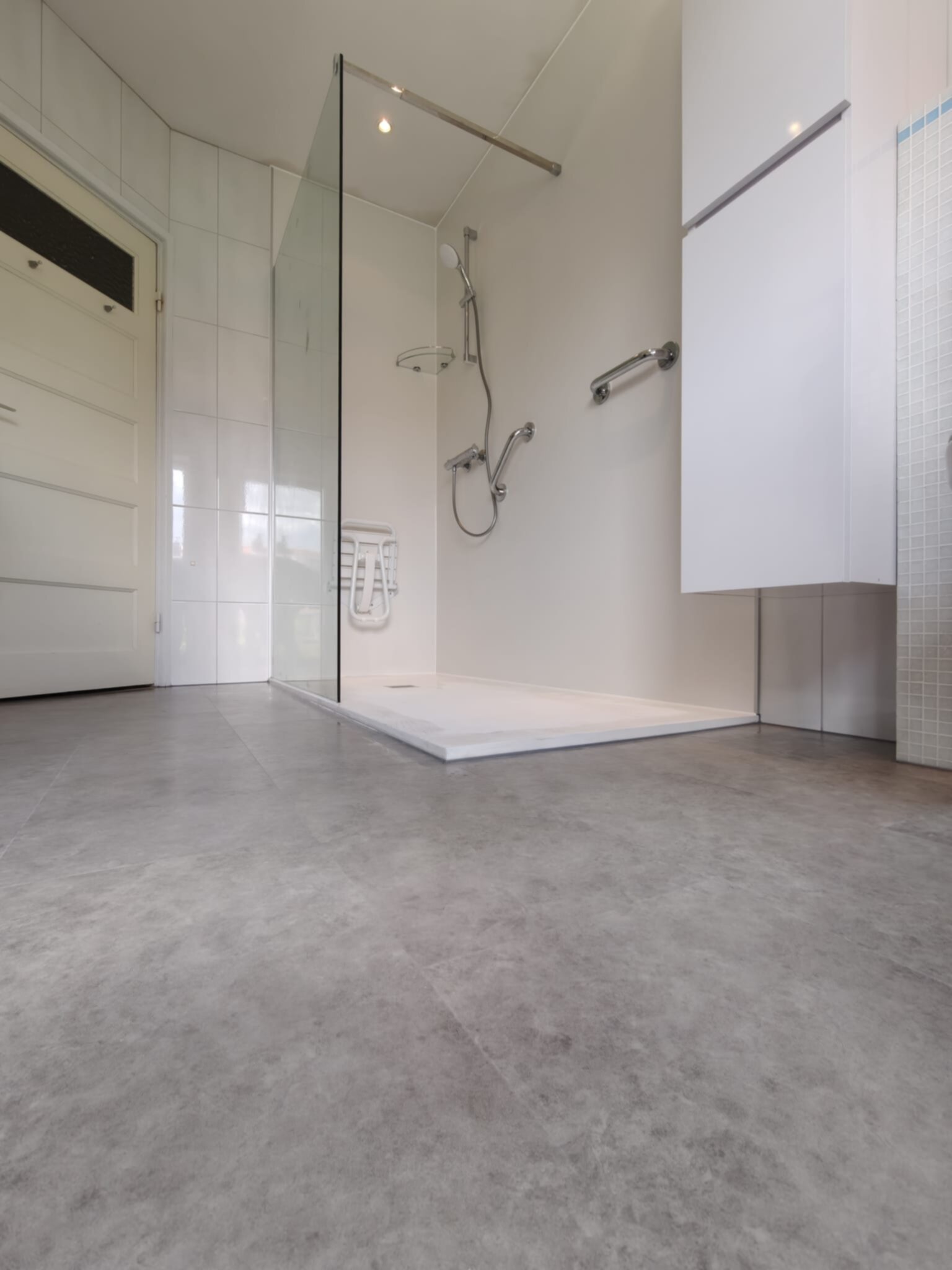 Moderne badkamer met grote glazen douchecabine en witte betegeling
