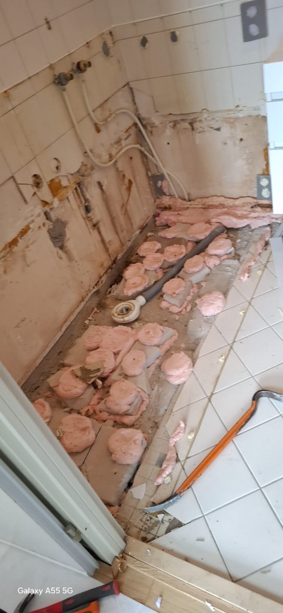 Sloop badkamer met rozige isolatie en oude tegels