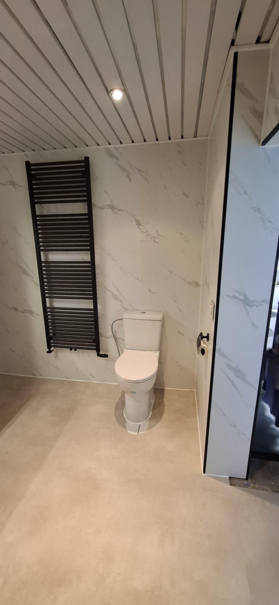 Moderne badkamer met witte toilet en marmeren wanden