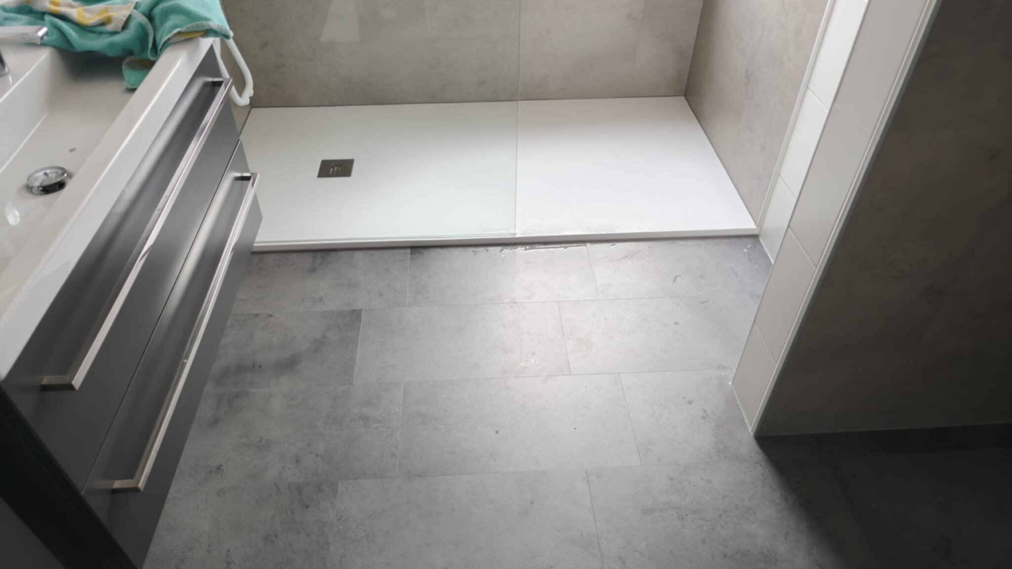 Moderne badkamer met grijze tegelvloer en witte douchebak