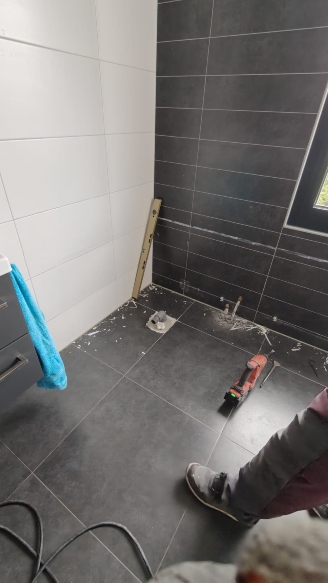 Tijdens badkamer renovatie, vloer en muur betegeld met grijs en wit