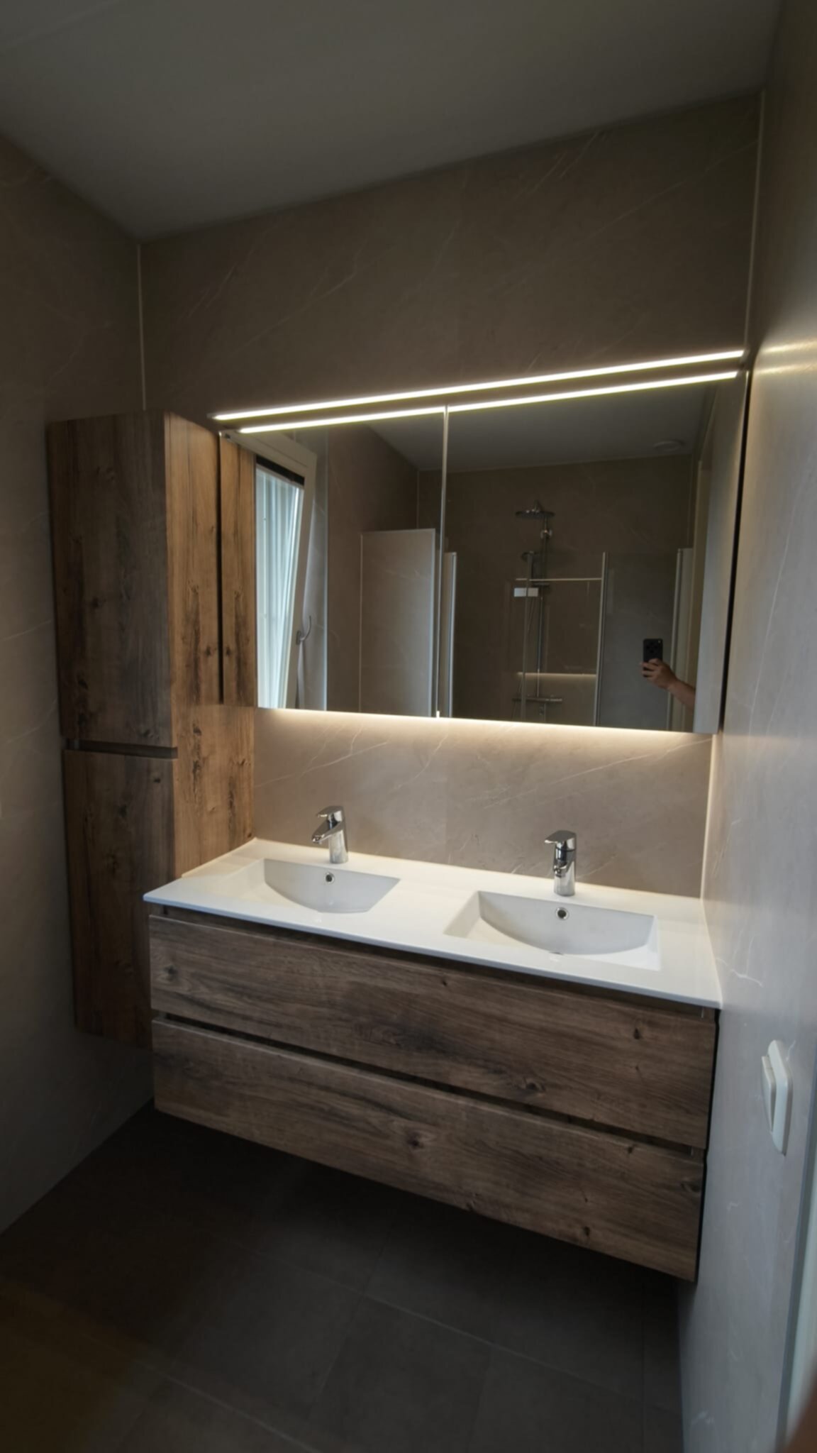 Dubbele wastafel met houten meubel en grote spiegel in moderne badkamer