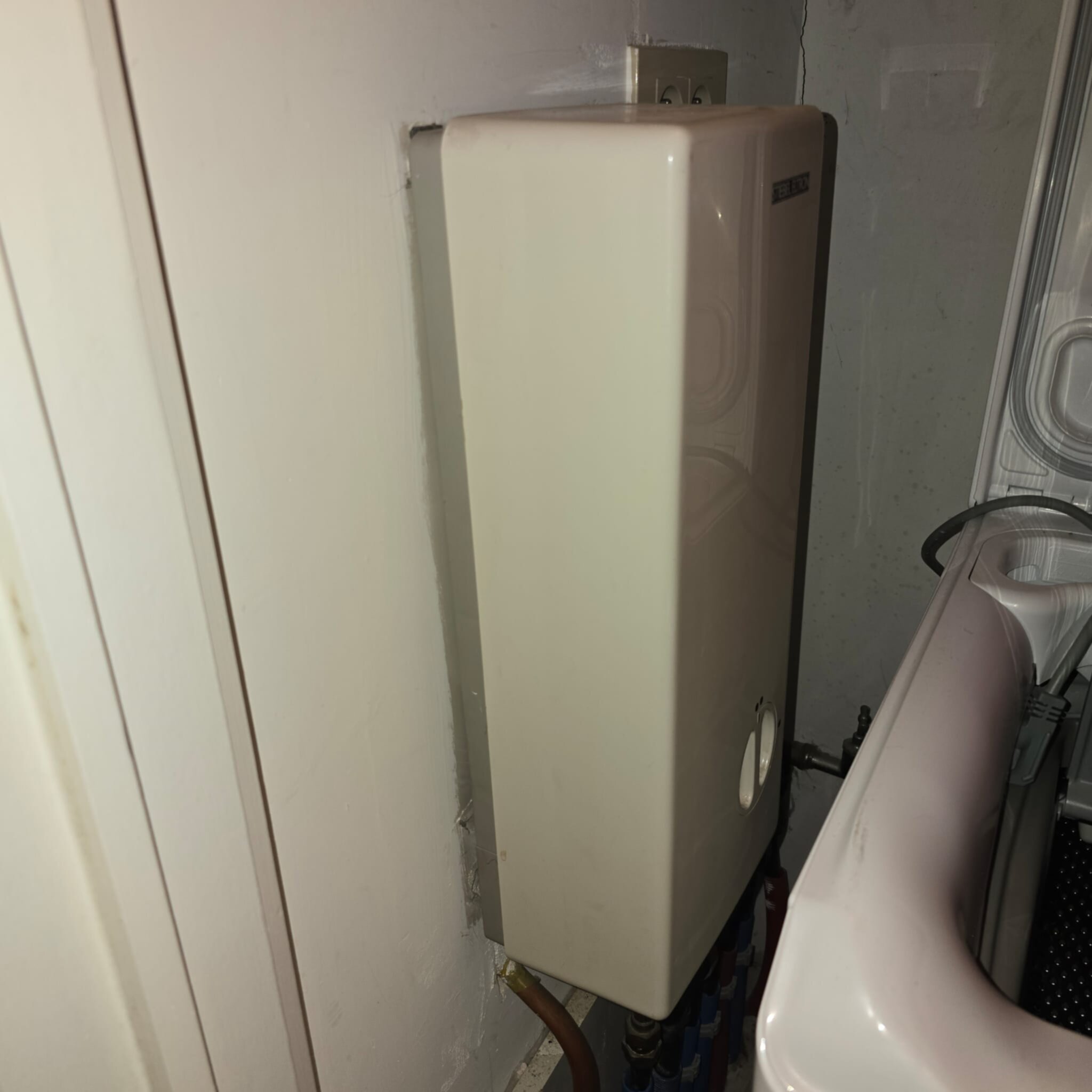 Een beige verwarmingsketel in een badkamer