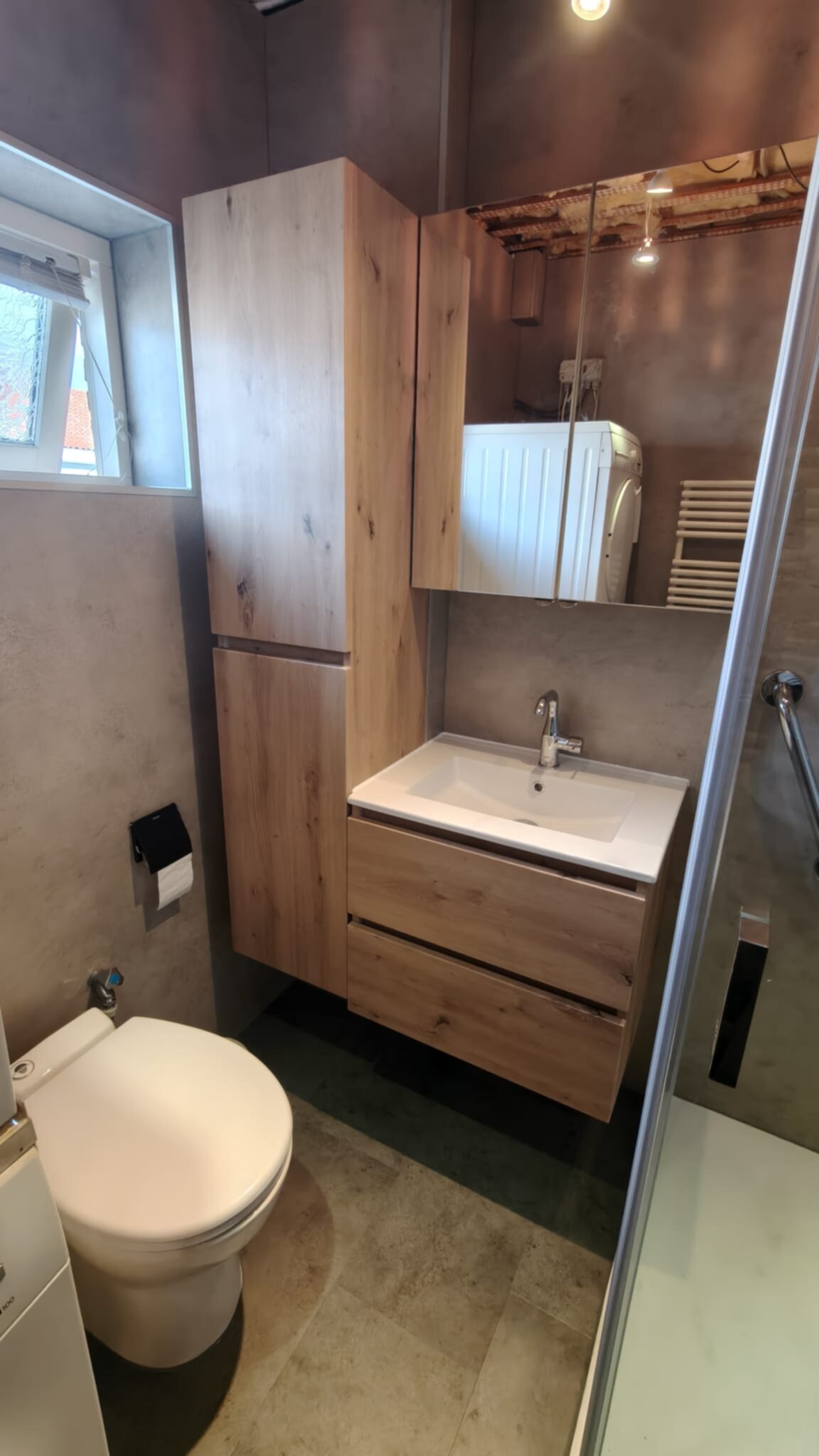 Badkamer met houten meubelen en grijze muren