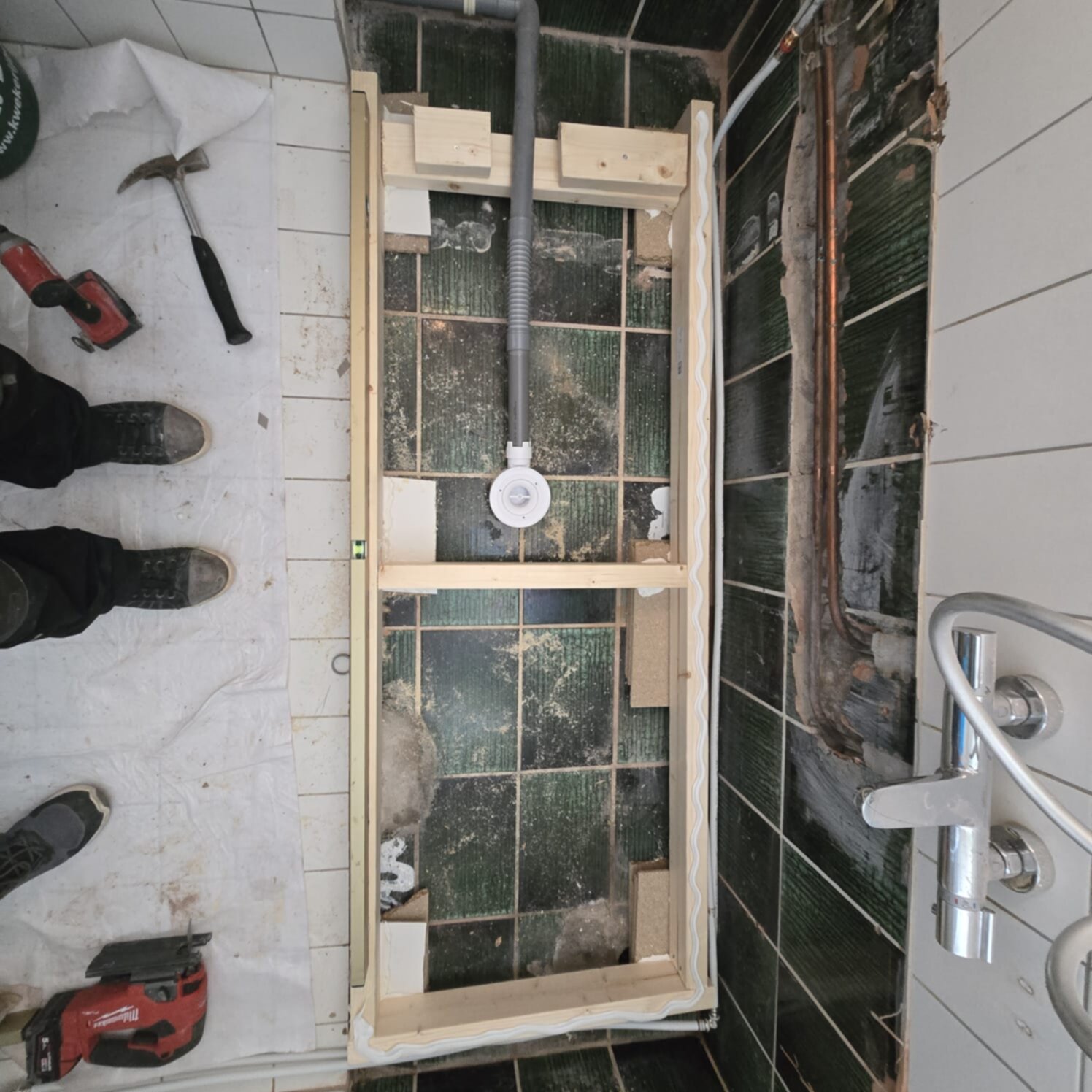 Badkamer renovatie in uitvoering, houten frame en gereedschap zichtbaar