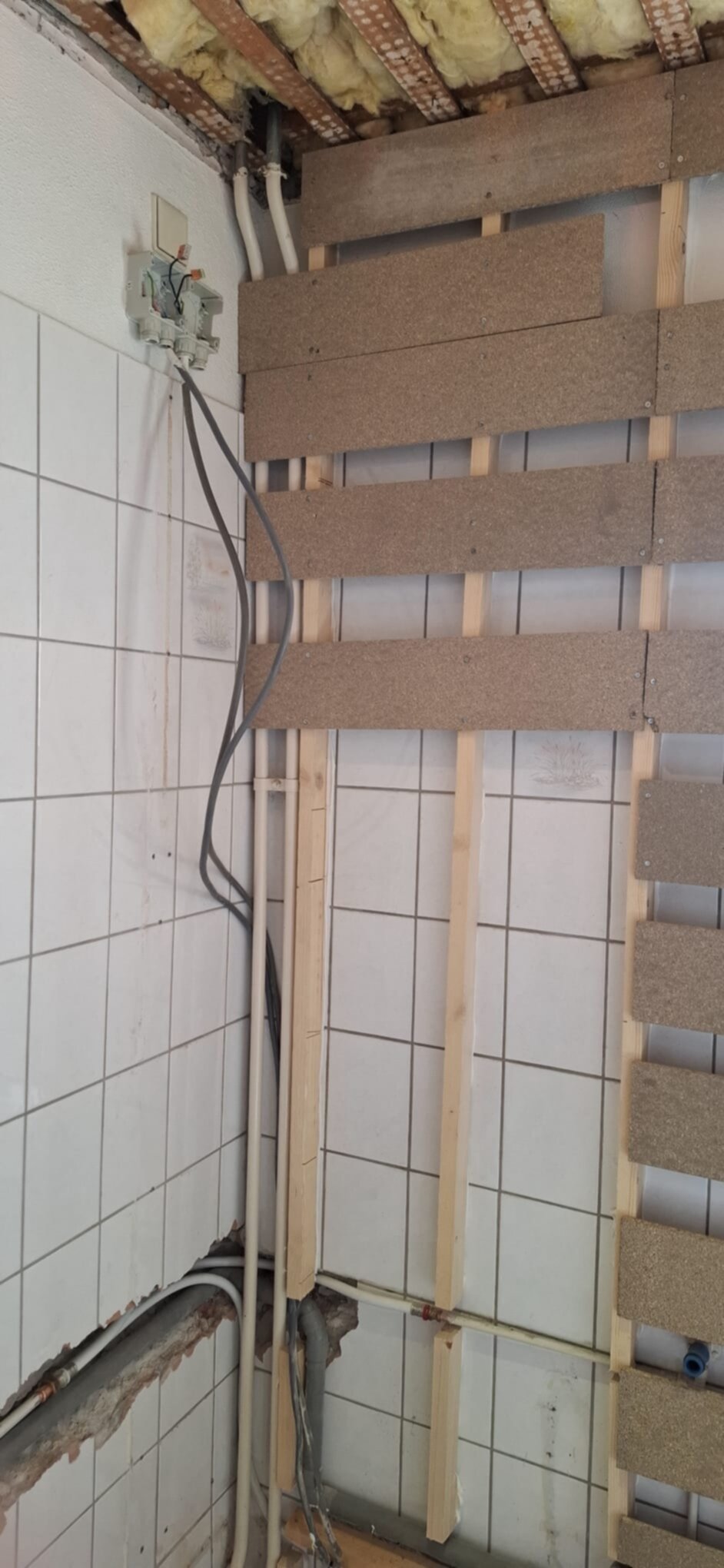 Badkamer renovatie in uitvoering met zicht op de betegelde wand en houten constructie