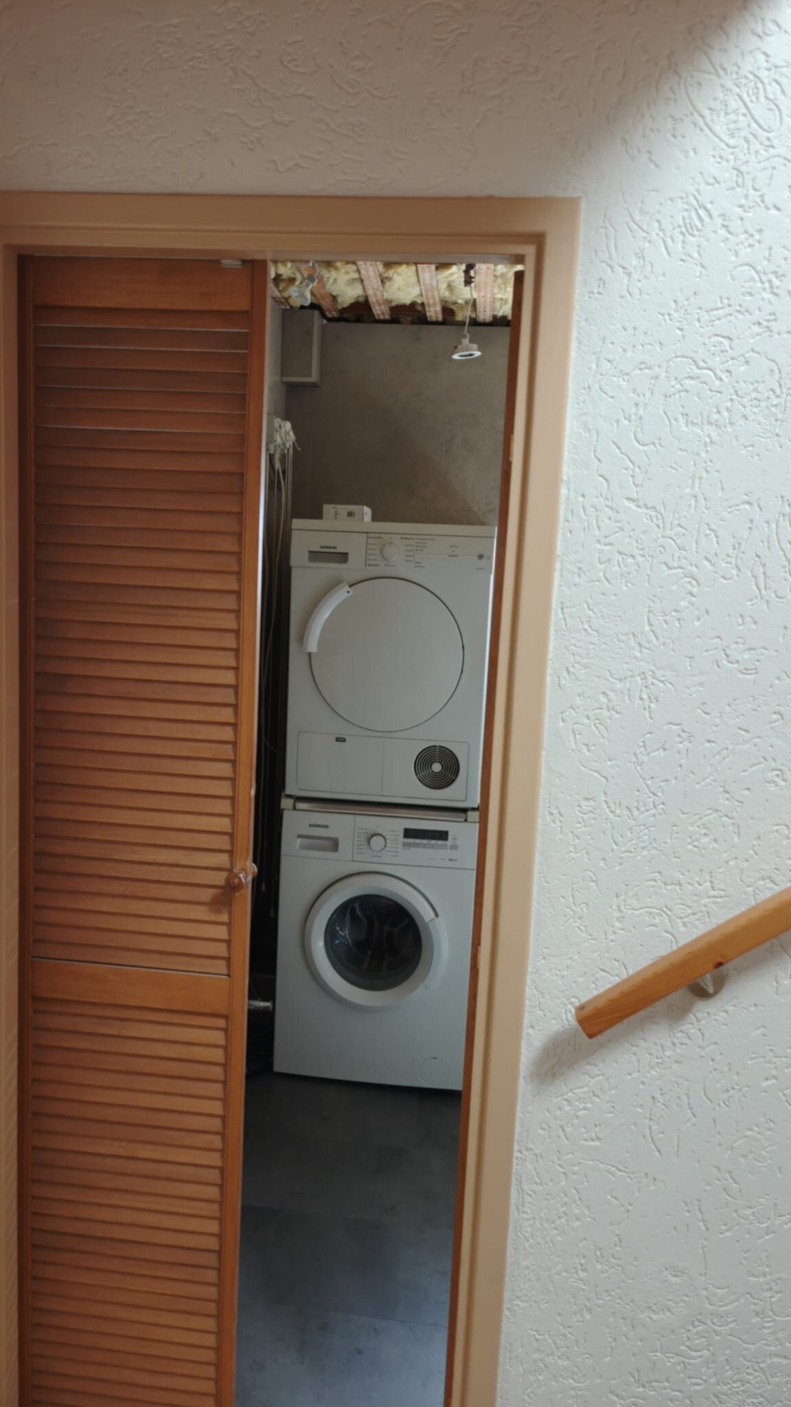 Wit stacked wasmachine en droger in kleine wasruimte